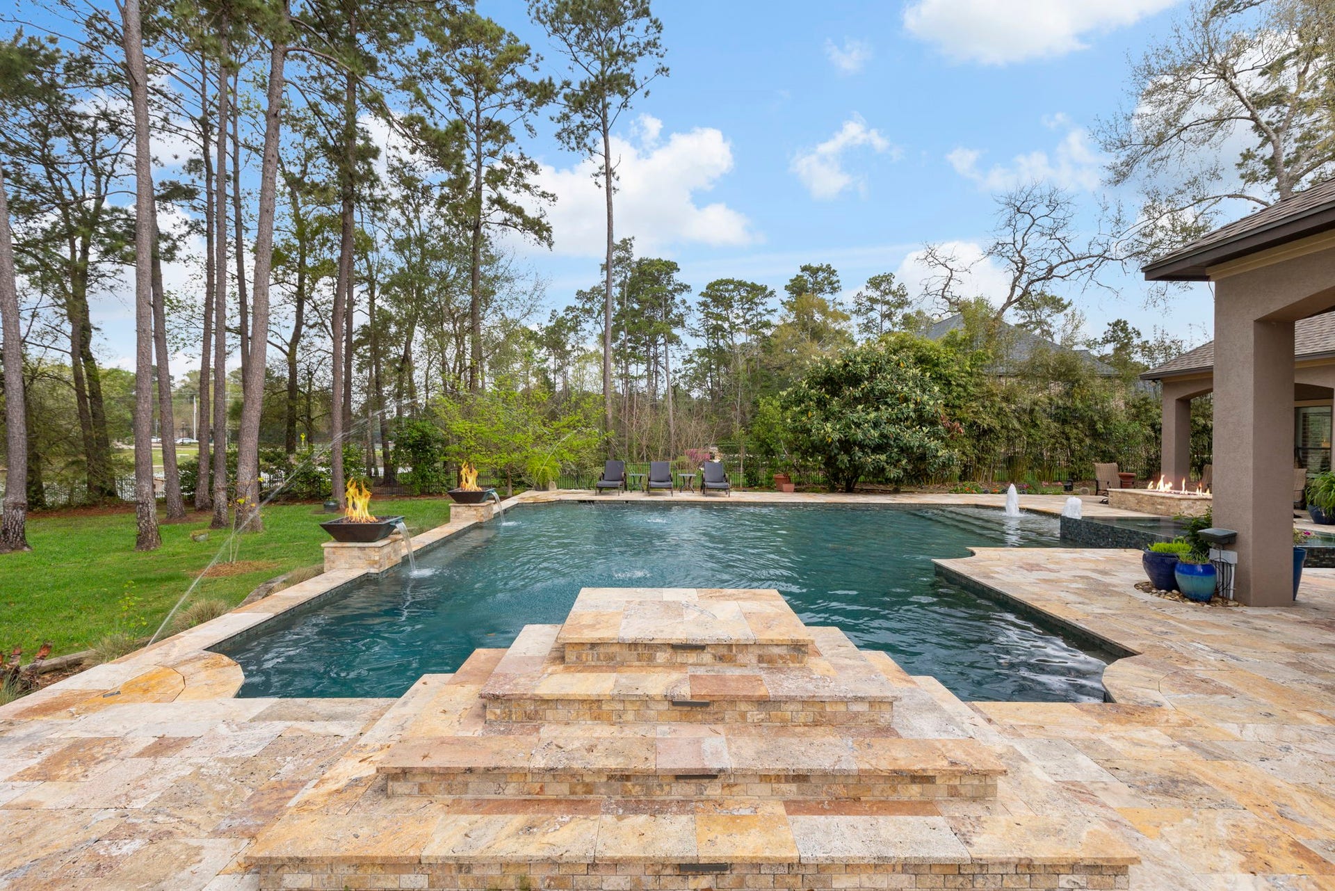 Impressive PebbleTec pool with 9' depth featuring fire/water bowls, bubblers, deck jets, a raised jump rock - a favorite with kids, plus poolside rock speakers! Designed for versatility with saltwater or chlorine operation; pool heater replaced in 2025.