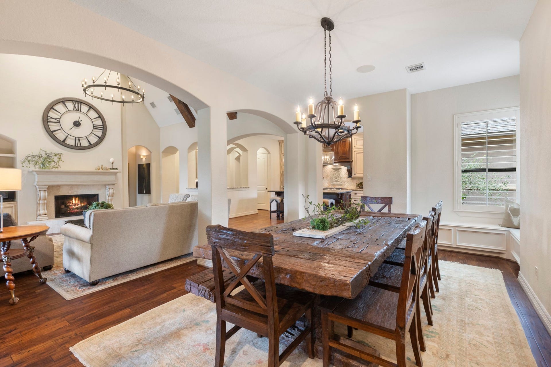 Generous family dining area (19' x 12') with wood flooring, decorative lighting, a charming window bench with storage, sound system, and direct access to the back patio.