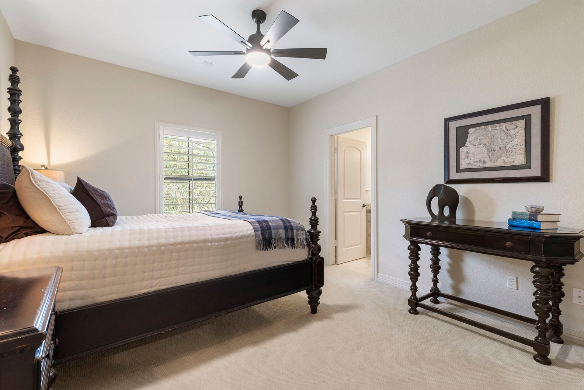 One of three spacious upstairs bedrooms, offering updated carpet, ceiling fan, and a large walk-in closet with custom built-in shelving.