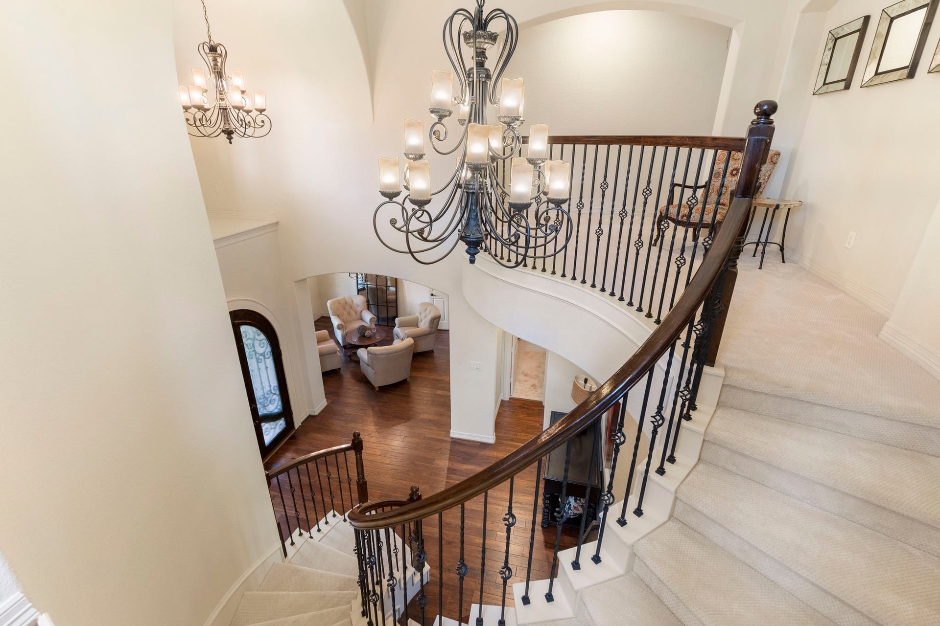Elegant curved staircase with wrought iron balusters creates a dramatic architectural centerpiece.