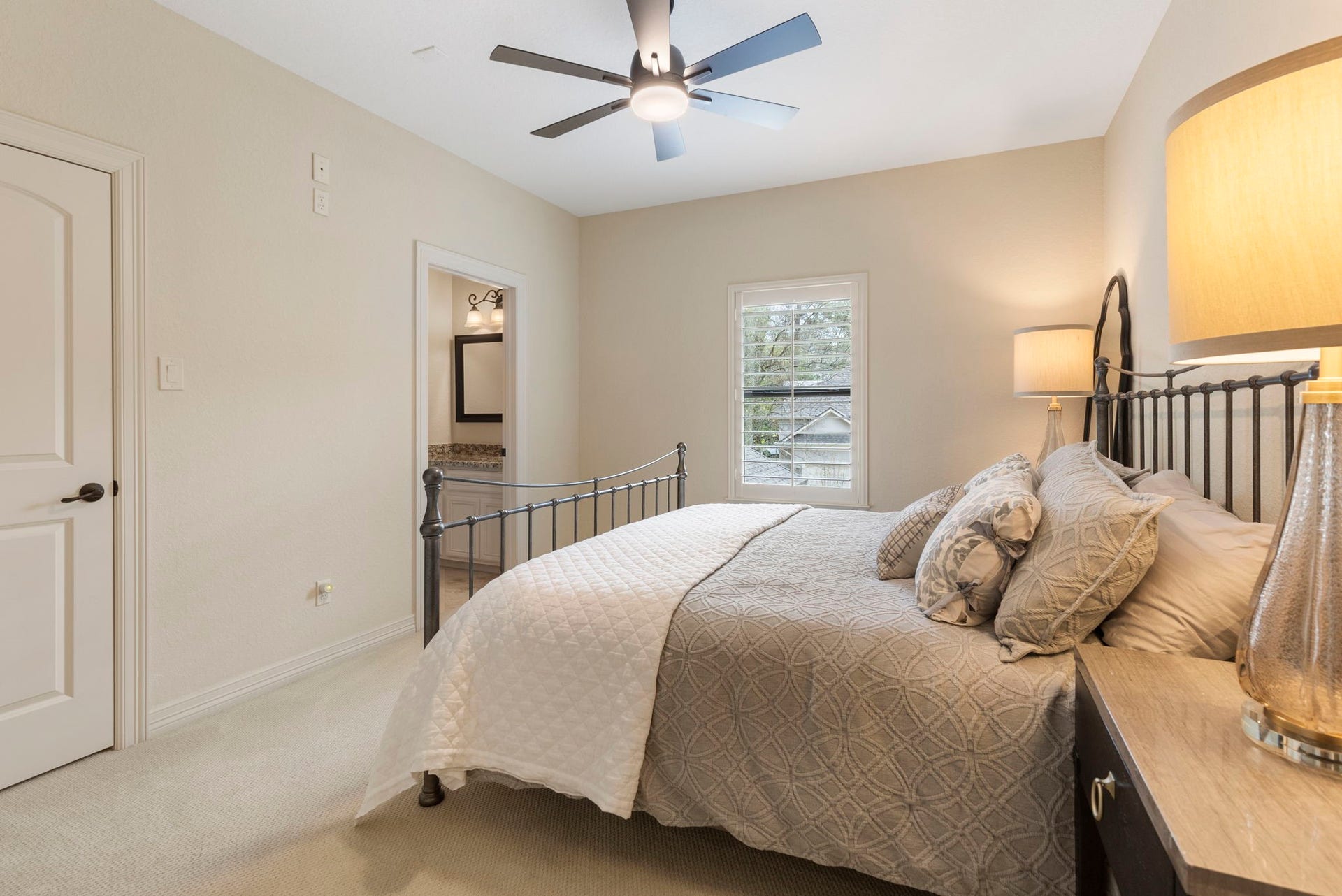 Spacious upstairs bedroom (14' x 11.5') featuring updated carpet, ceiling fan, and a large walk-in closet with built-in shelving.