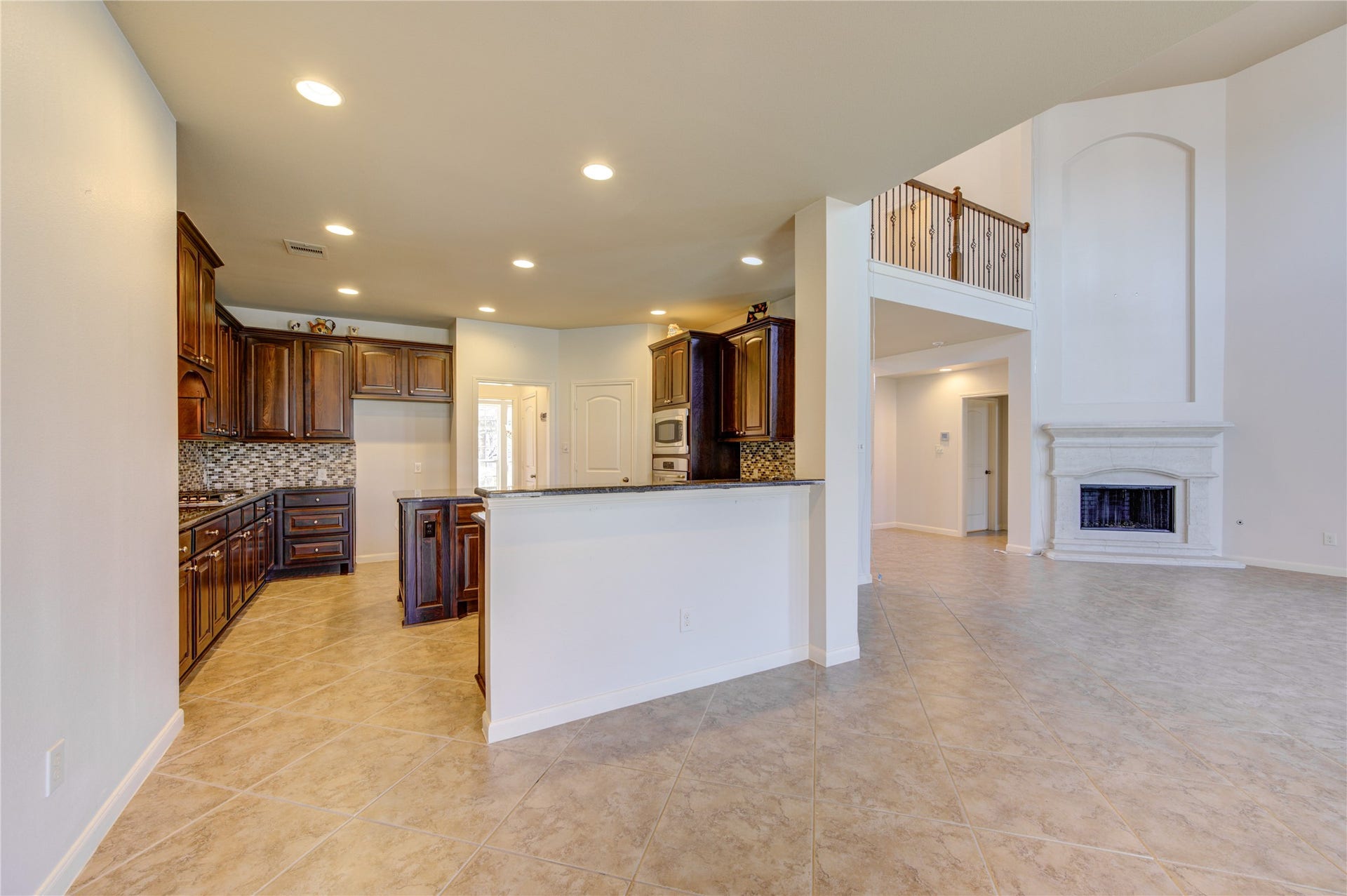 Bar area infront of 360 island kitchen, granite counters and modern appliances.
