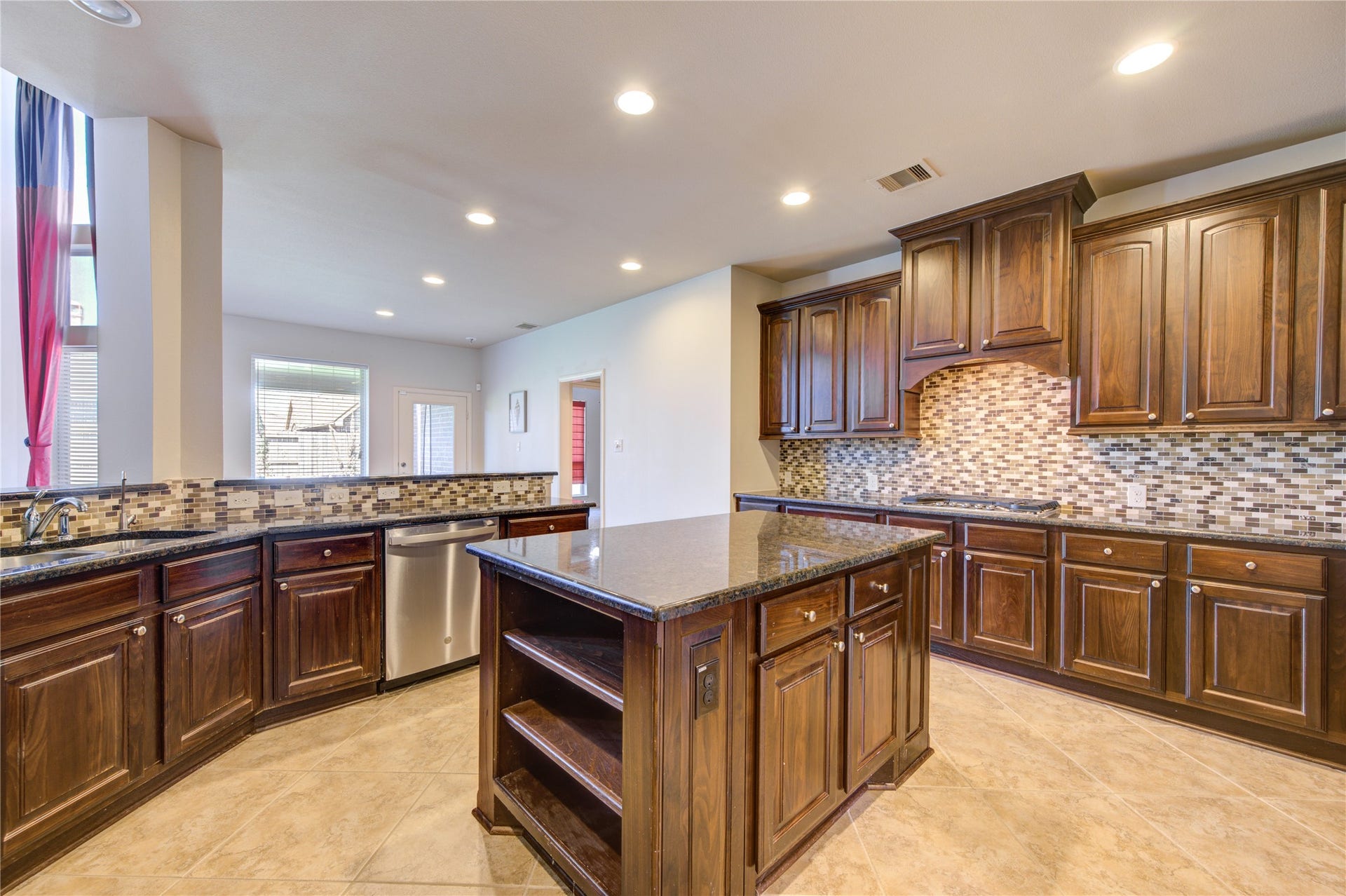 Large kitchen granite island with tile backplash