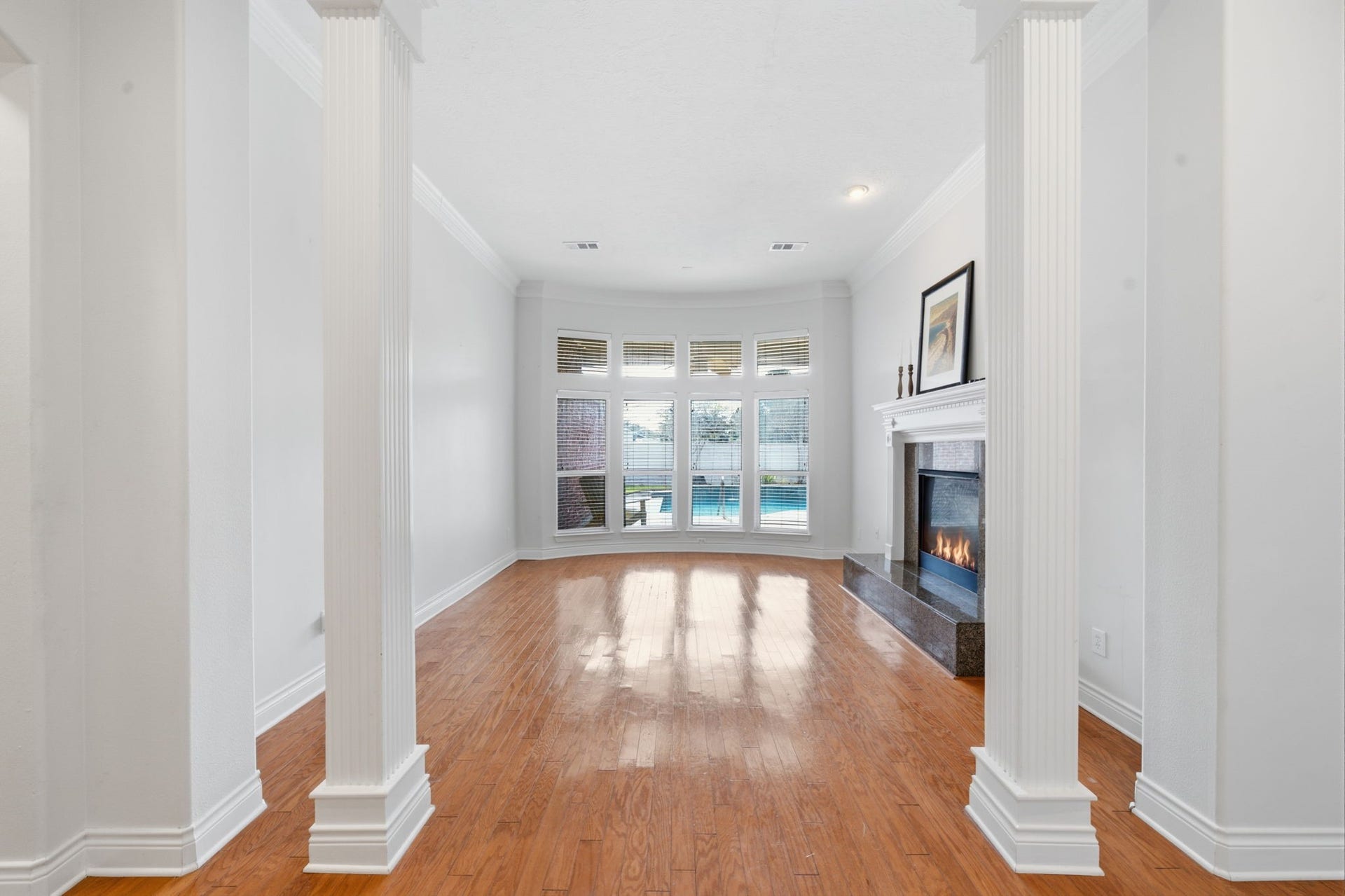 1227 Wellshire Drive, Katy, TX 77494 The formal living room includes a remote controlled fireplace, focal columns and a view of the pool.