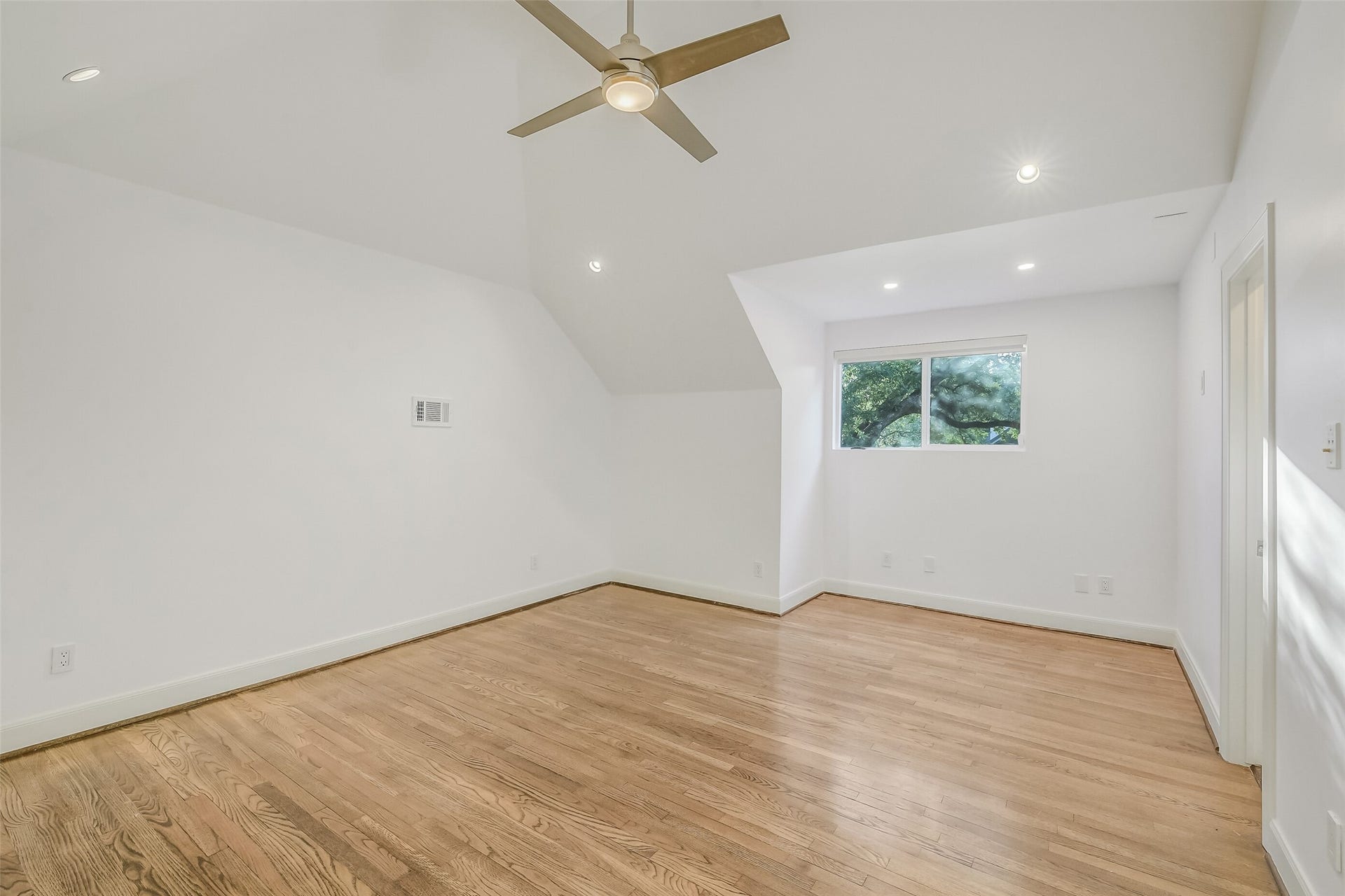 Located on the second floor, this inviting secondary bedroom offers a comfortable retreat with soaring vaulted ceilings, beautiful hardwood floors, and a private en-suite bathroom for added comfort and convenience.