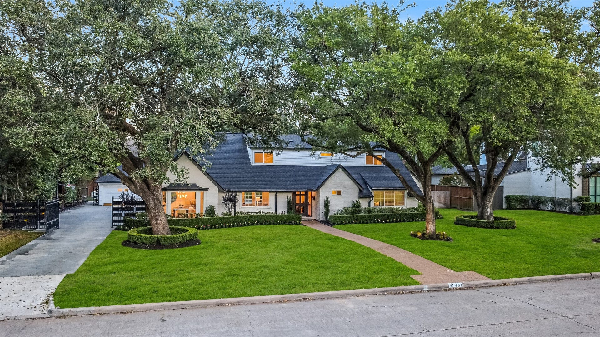Beautifully maintained home nestled among majestic mature trees, featuring a sprawling front lawn, manicured landscaping, and privacy gate. Make 451 Brown Saddle Your Home!