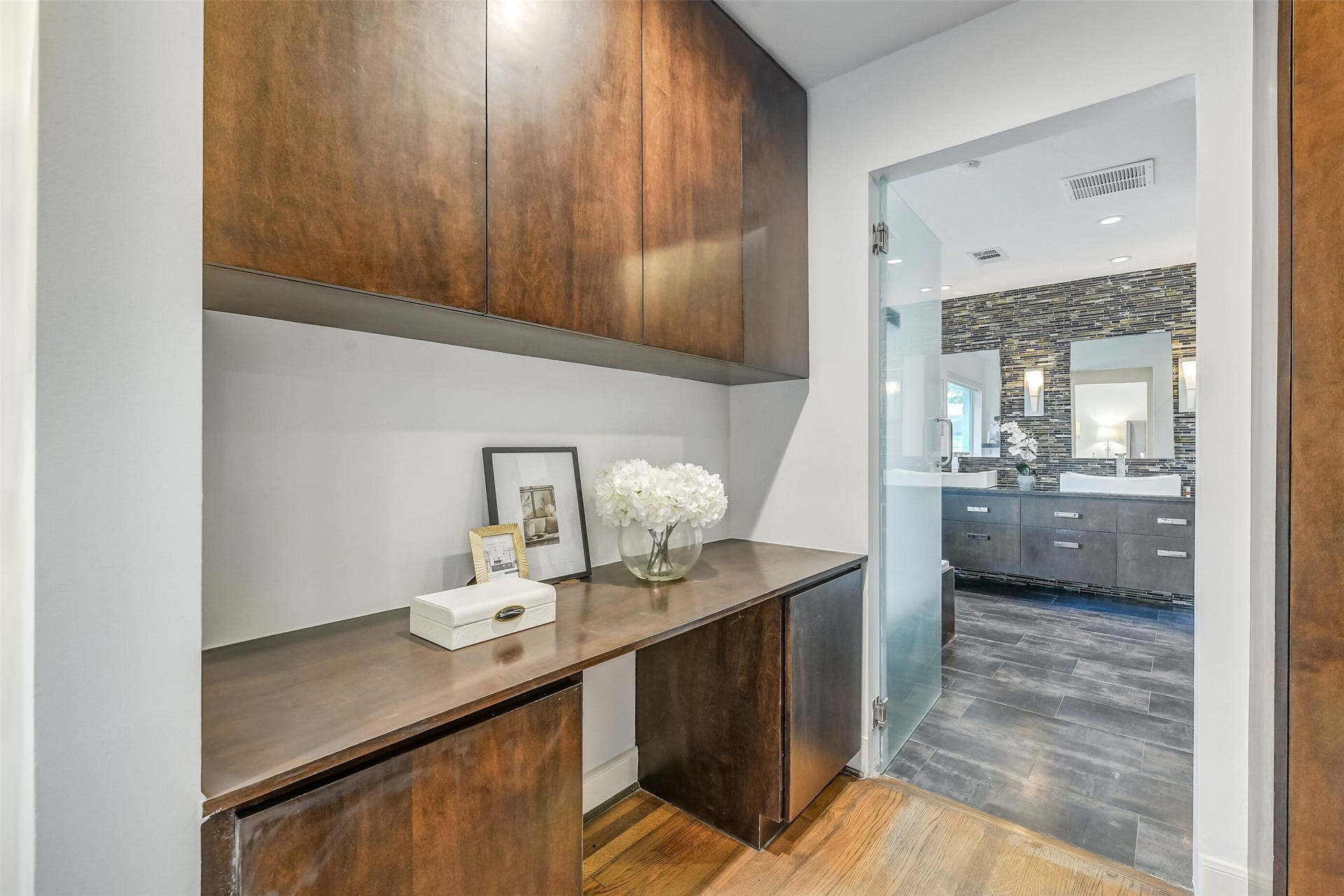 Thoughtfully designed connecting space between the primary bedroom and bath, featuring a custom built-in vanity with generous counter space and ample storage for added comfort and convenience.