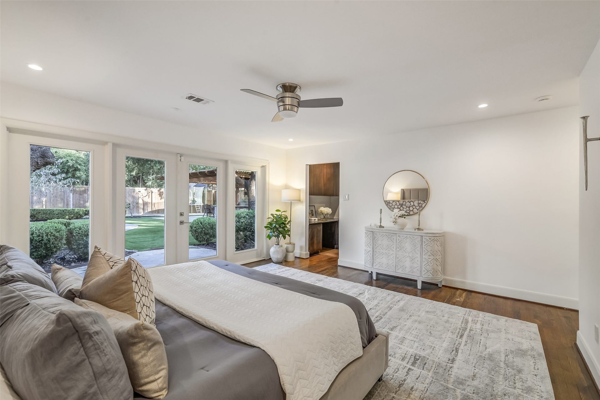 Another view of the primary bedroom, enjoy beautiful views of the the lush landscaping and pool area from the comfort of your private retreat.