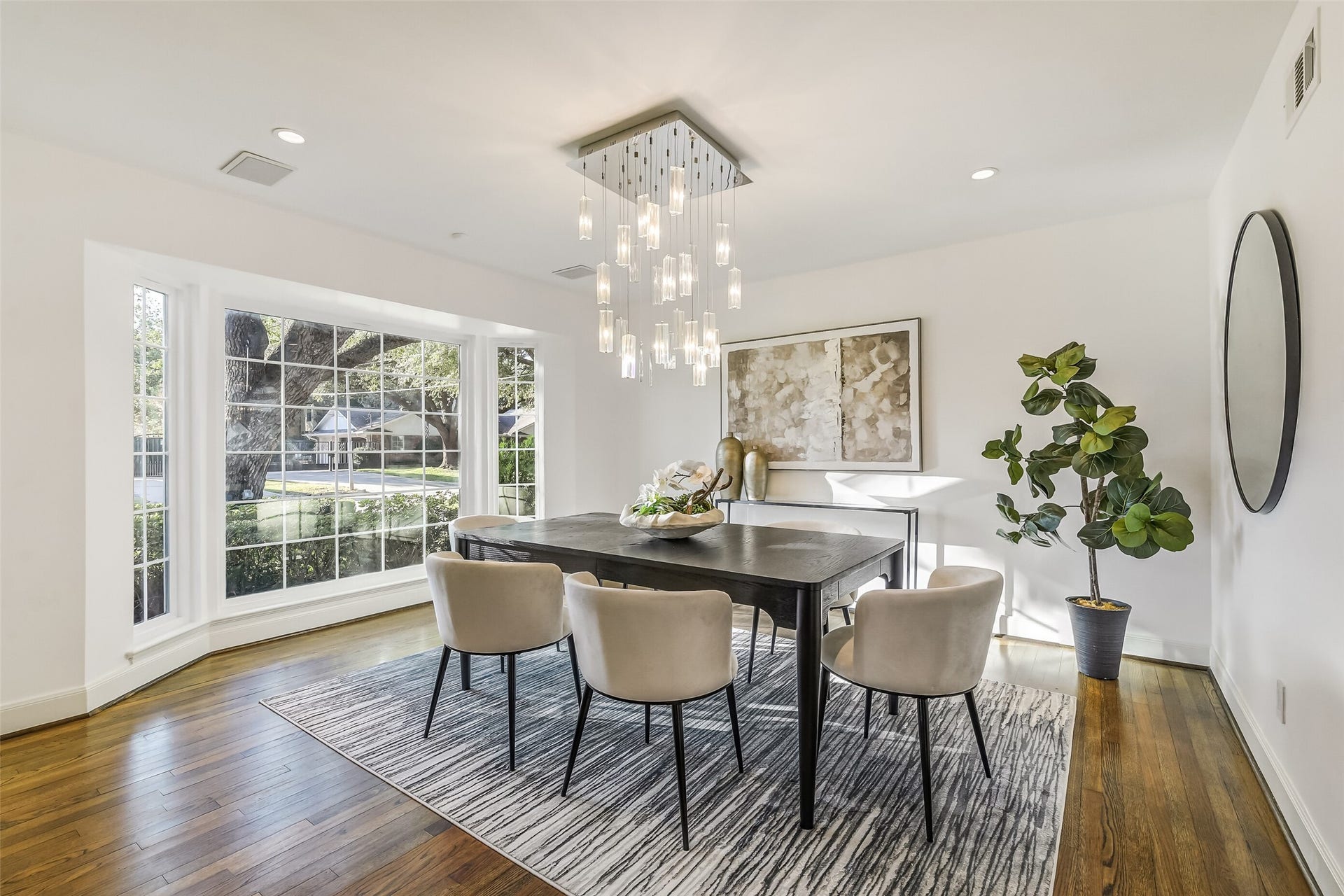 Spacious and elegant formal dining room featuring expansive bay windows that fill the space with natural light while offering picturesque views, creating a beautiful setting for intimate dinners and memorable gatherings.