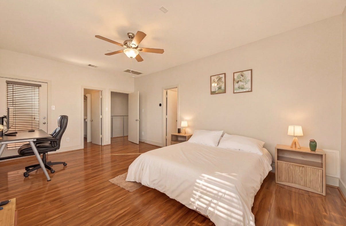 5111 Cornish Street, Houston, TX 77007 Spacious bedroom featuring warm hardwood floors, a cozy bed with stylish side tables, and a convenient workspace with a modern desk.