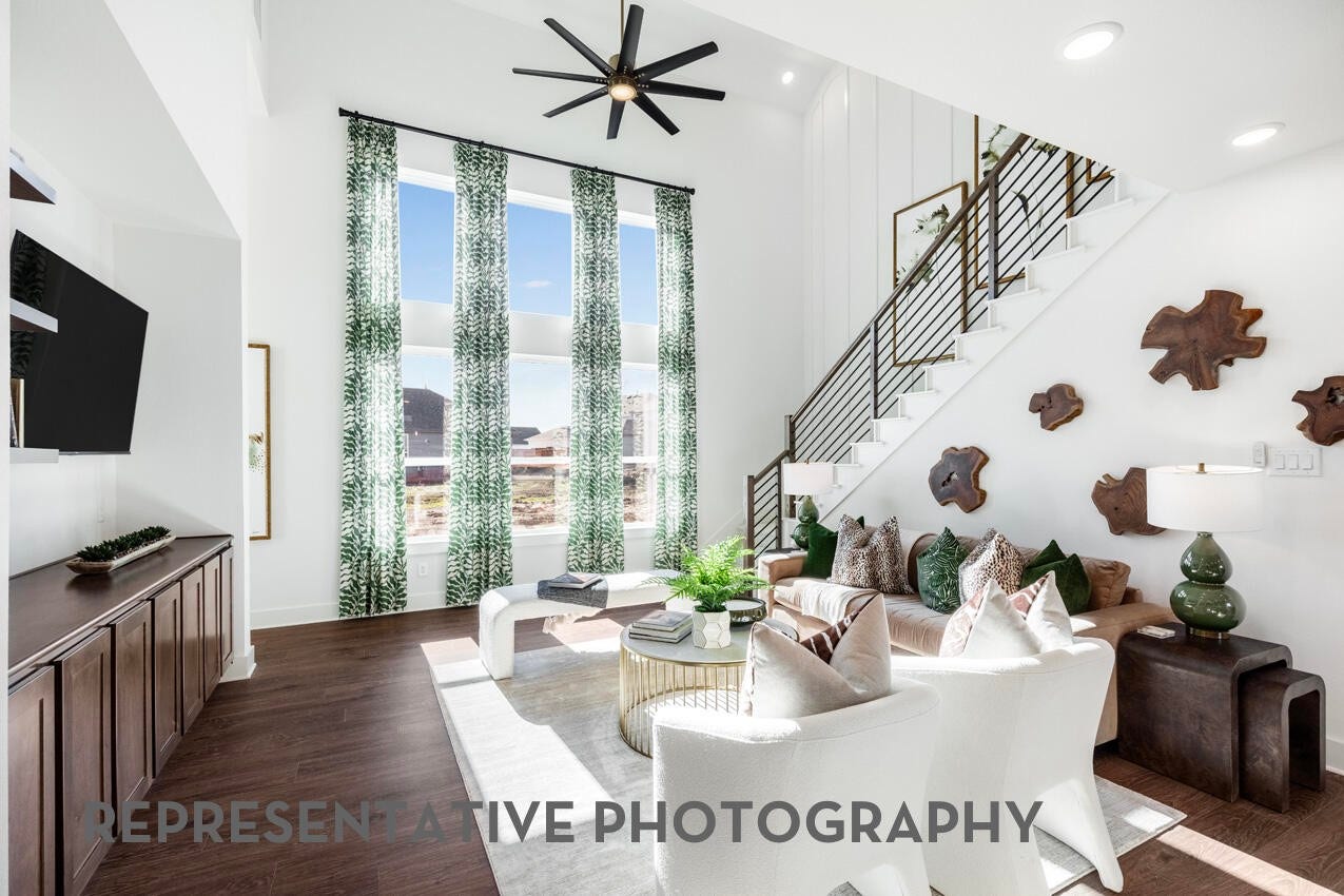 3435 Loam Lane, Richmond, TX 77406 A spacious family room with high ceilings opens to the kitchen and features elegant balusters leading to the upstairs, creating a bright and connected gathering space.