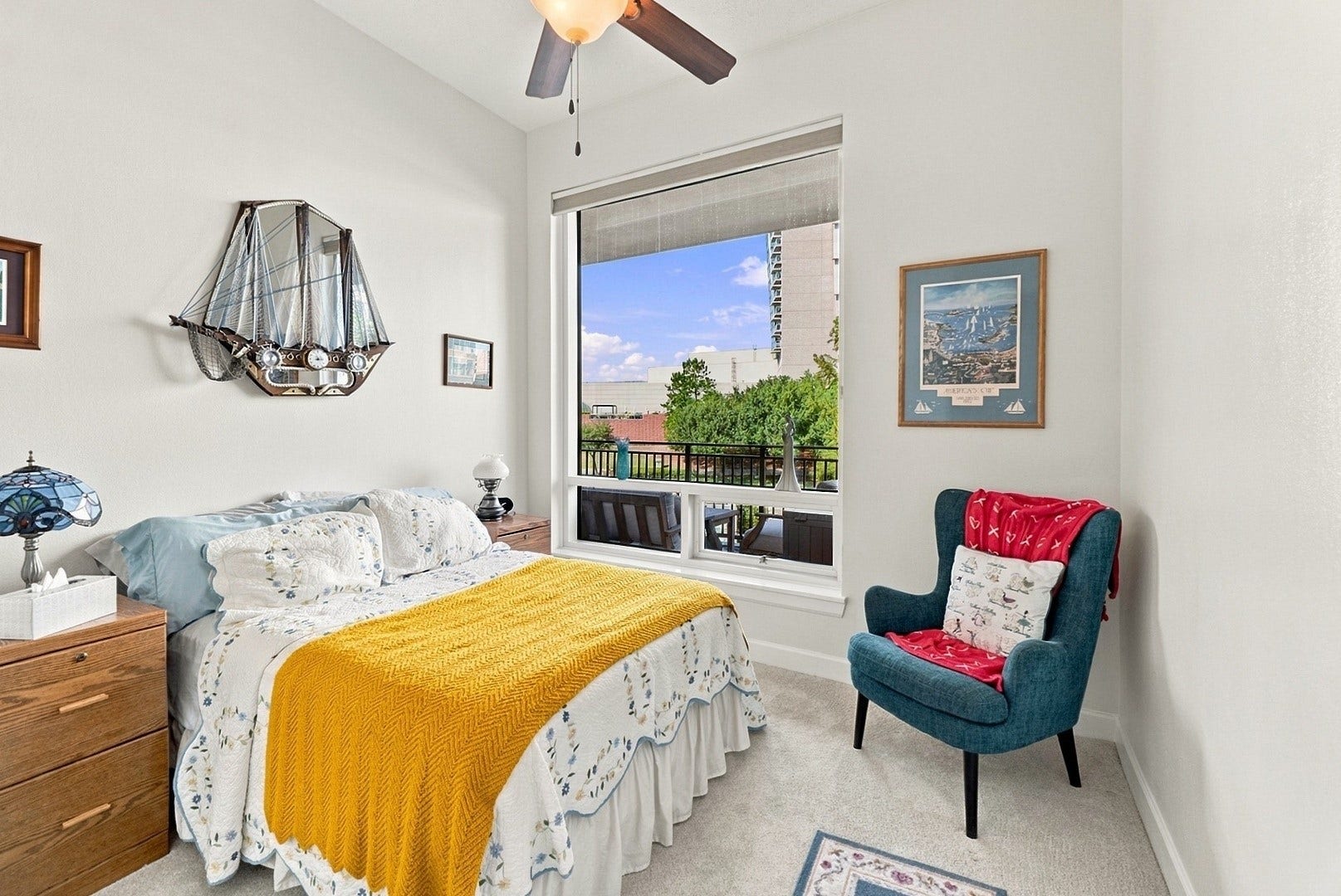 3 Waterway Court, #2D, The Woodlands, TX 77380 Light-filled bedroom with a large window, ceiling fan, and comfortable space to relax and unwind.