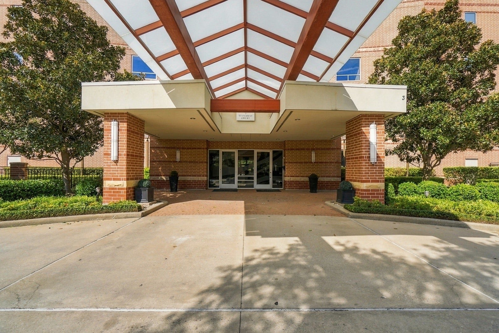 3 Waterway Court, #2D, The Woodlands, TX 77380 Welcoming building entrance featuring a spacious covered drive and attractive architectural design.