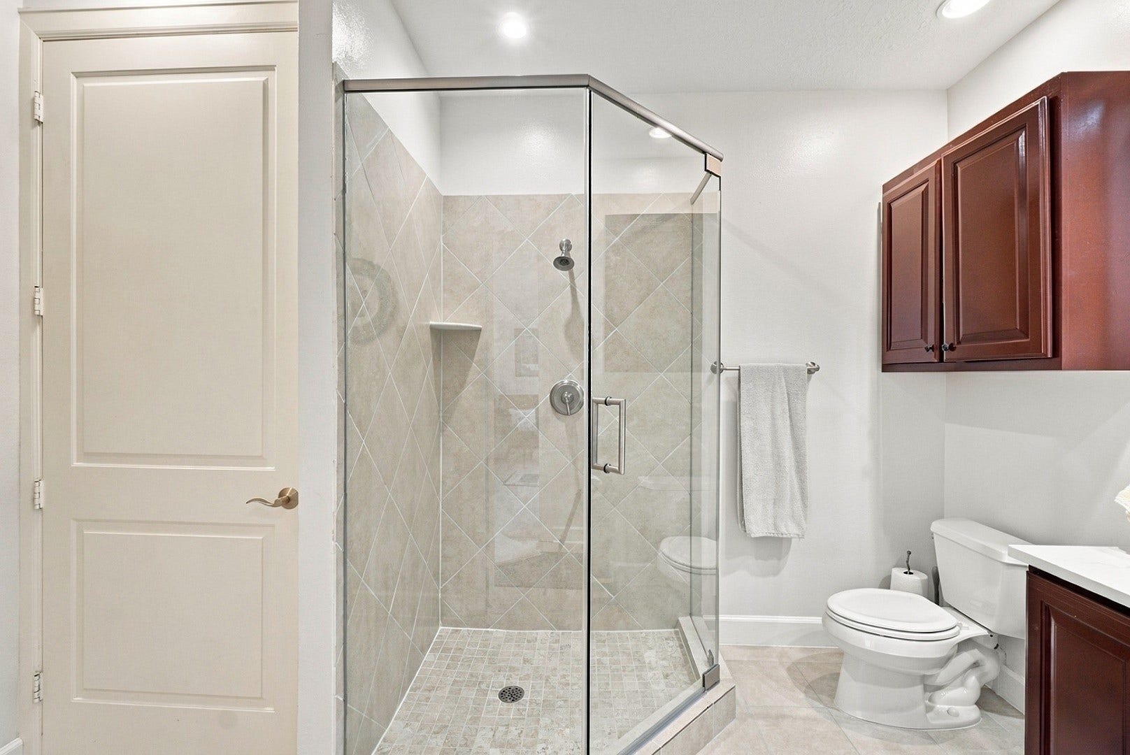 3 Waterway Court, #2D, The Woodlands, TX 77380 Well-appointed bathroom featuring a glass-enclosed shower, neutral tile, and generous vanity storage.