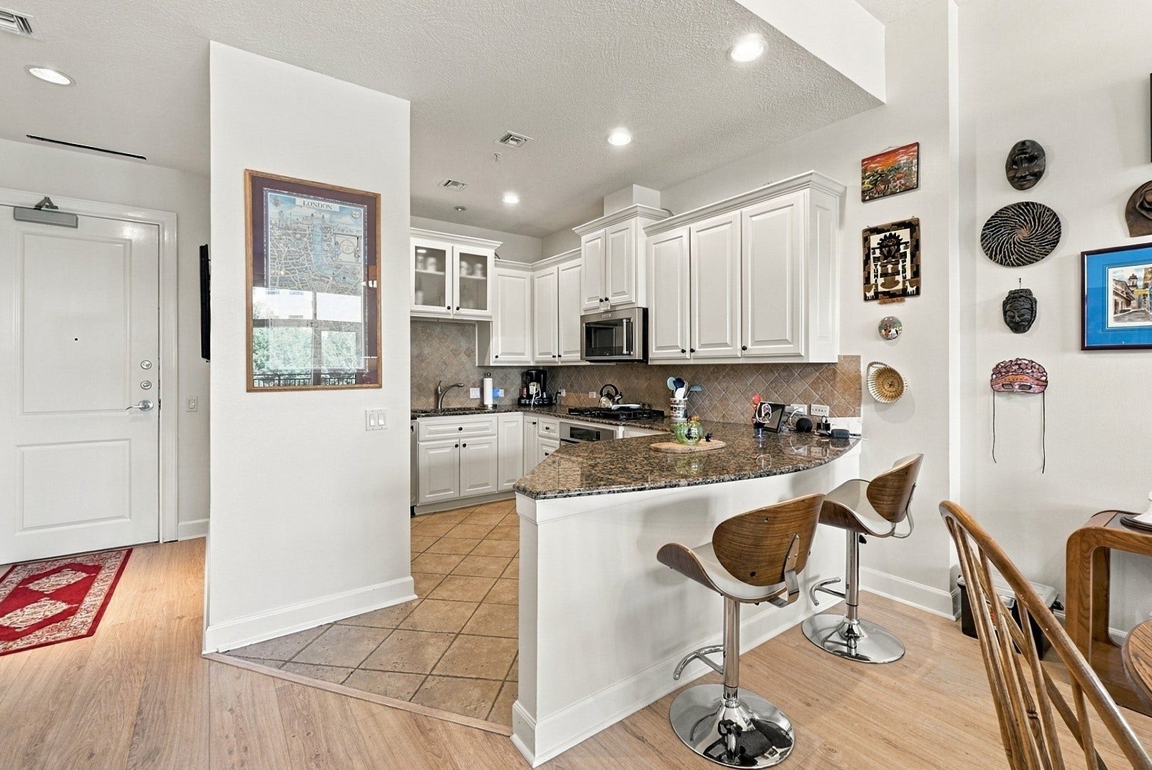 3 Waterway Court, #2D, The Woodlands, TX 77380 Spacious kitchen with granite countertops, breakfast bar seating, and an effortless flow into the dining area.