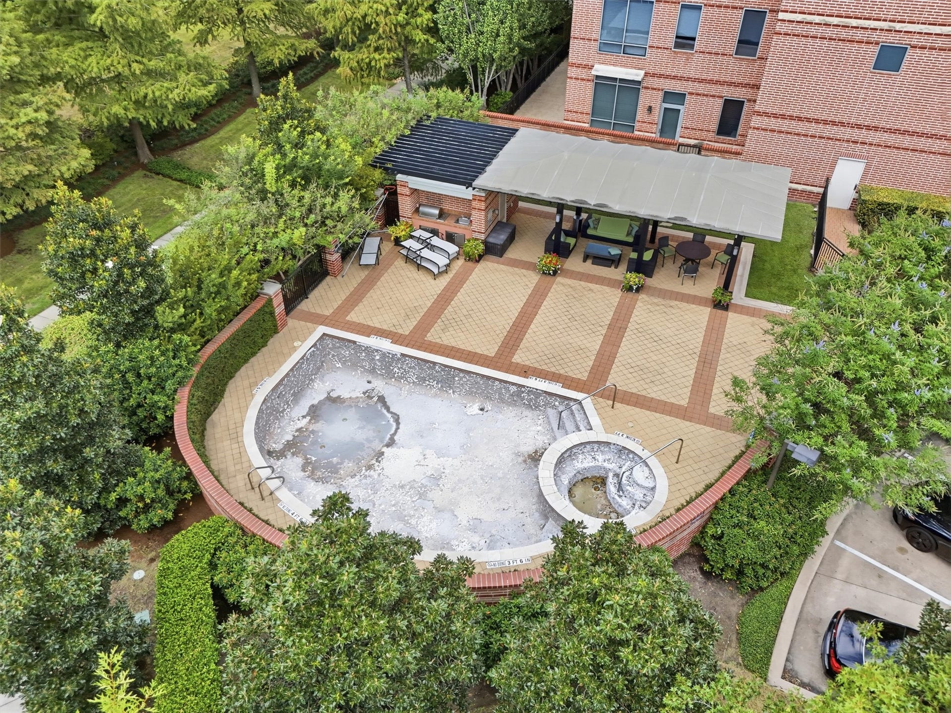 3 Waterway Court, #2D, The Woodlands, TX 77380 A bird's-eye view of the community pool and outdoor gathering areas surrounded by lush greenery. Currently being replastured.