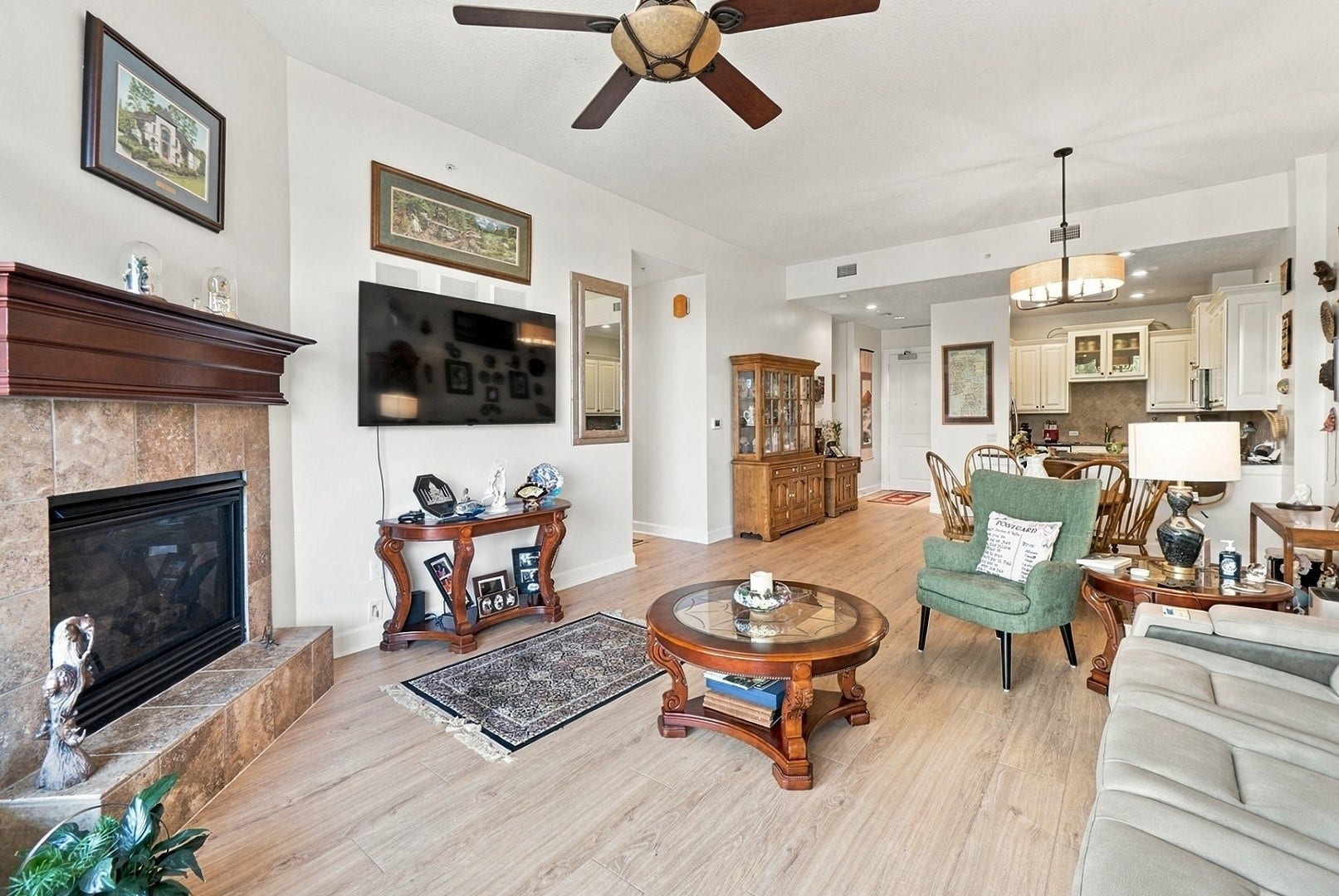 3 Waterway Court, #2D, The Woodlands, TX 77380 Inviting living area featuring a fireplace, wood flooring, and an open layout designed for comfort and entertaining.