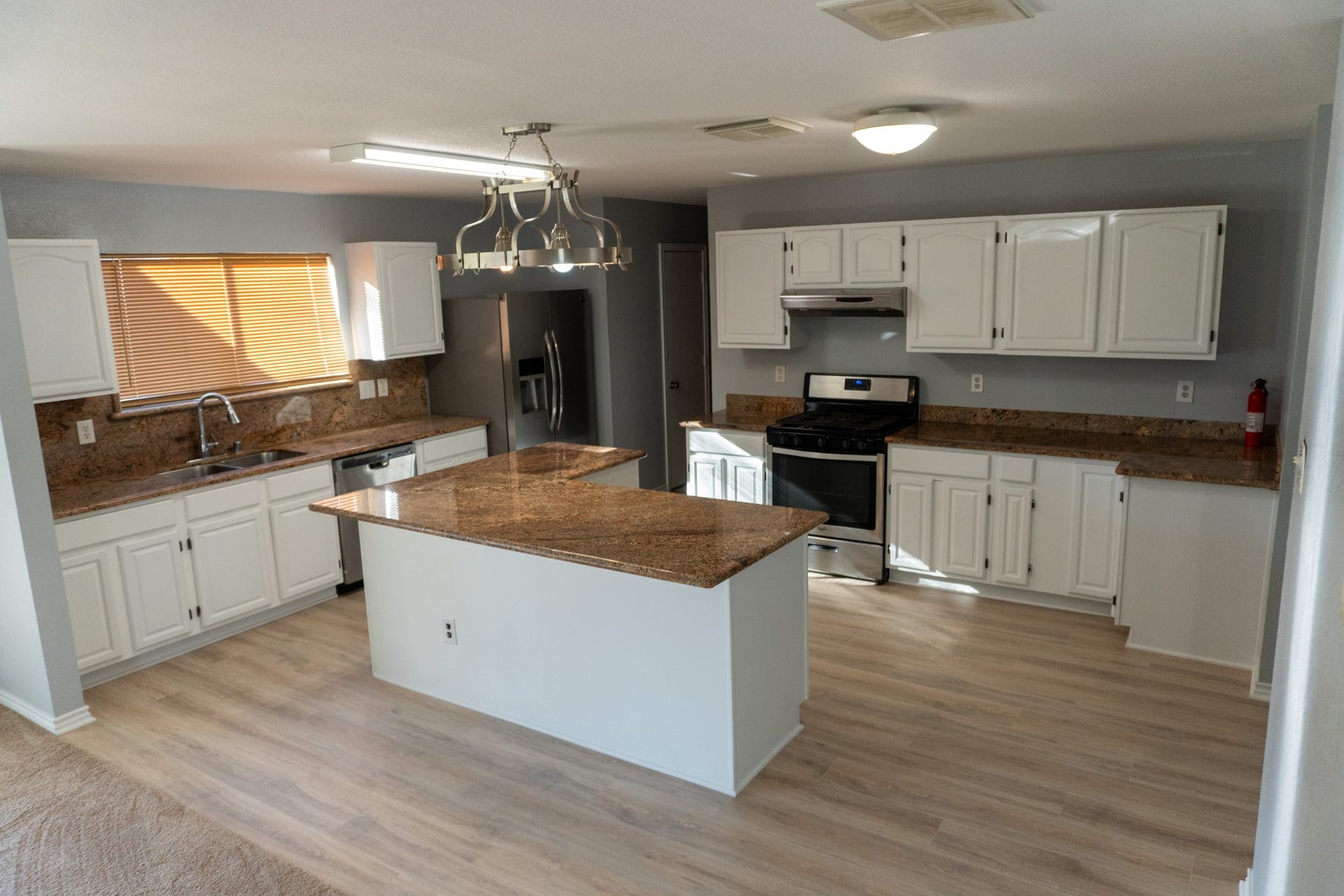 7627 Greenwood Point Drive, Cypress, TX 77433 Spacious kitchen featuring modern stainless steel appliances, elegant granite countertops, and ample white cabinetry, complemented by a central island for additional workspace.