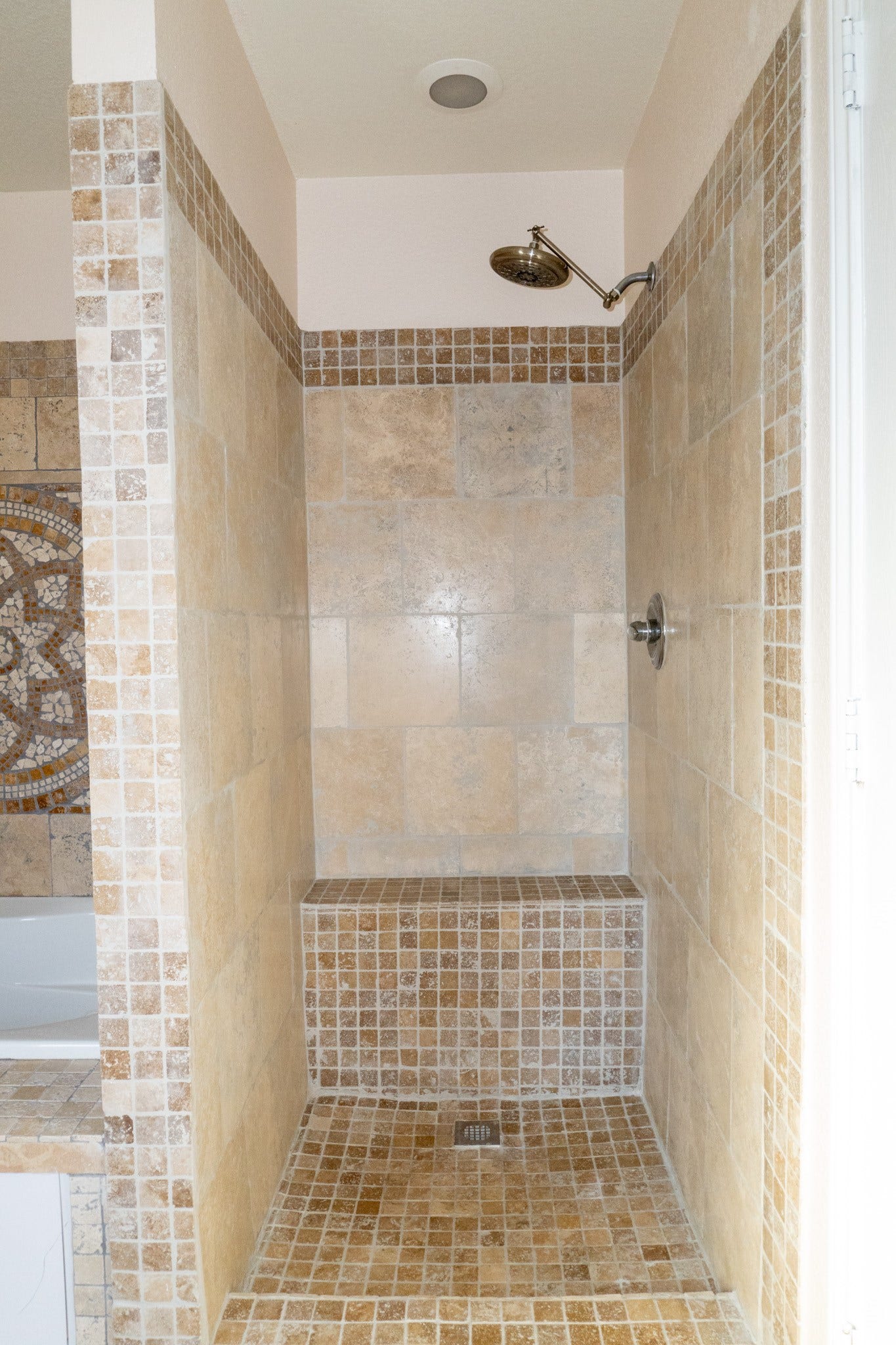 7627 Greenwood Point Drive, Cypress, TX 77433 Spacious walk-in shower featuring elegant tile work and a built-in bench for added comfort.