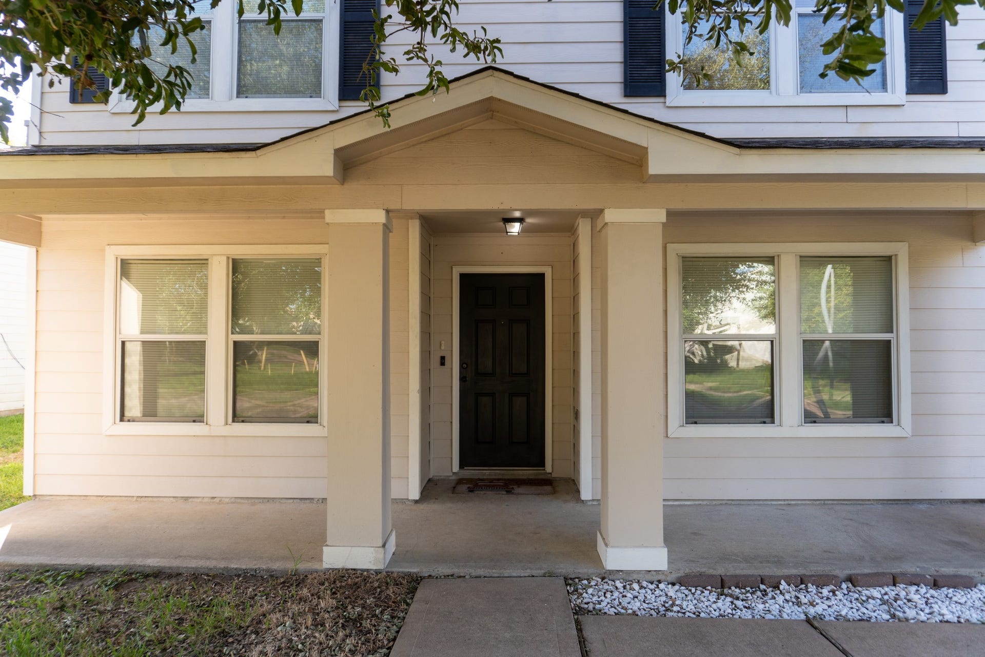 7627 Greenwood Point Drive, Cypress, TX 77433 Stunning front entrance with a welcoming covered porch, flanked by twin windows and adorned with manicured landscaping.