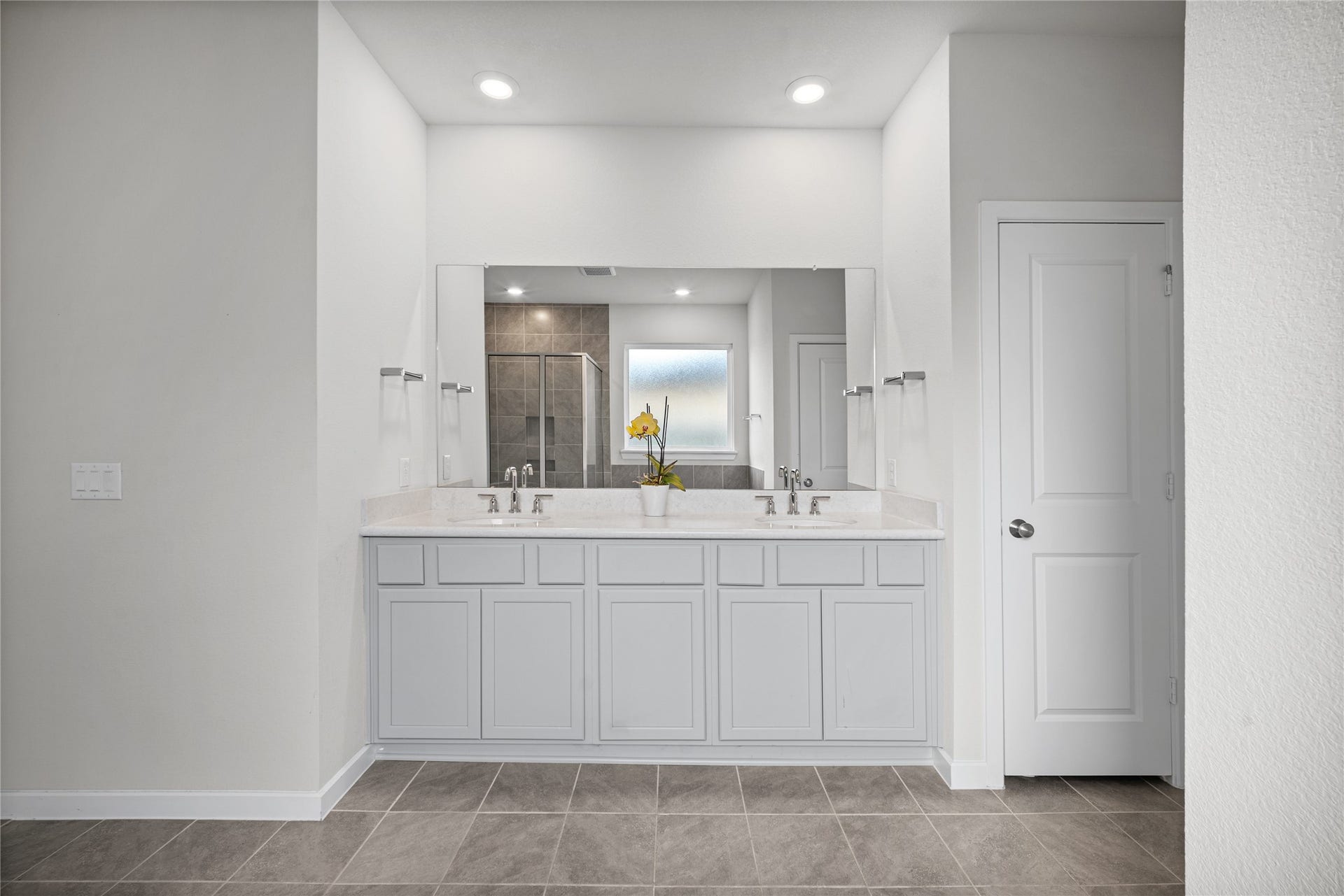 Light finishes and generous vanity space give the owners bath a bright, refreshed feel.