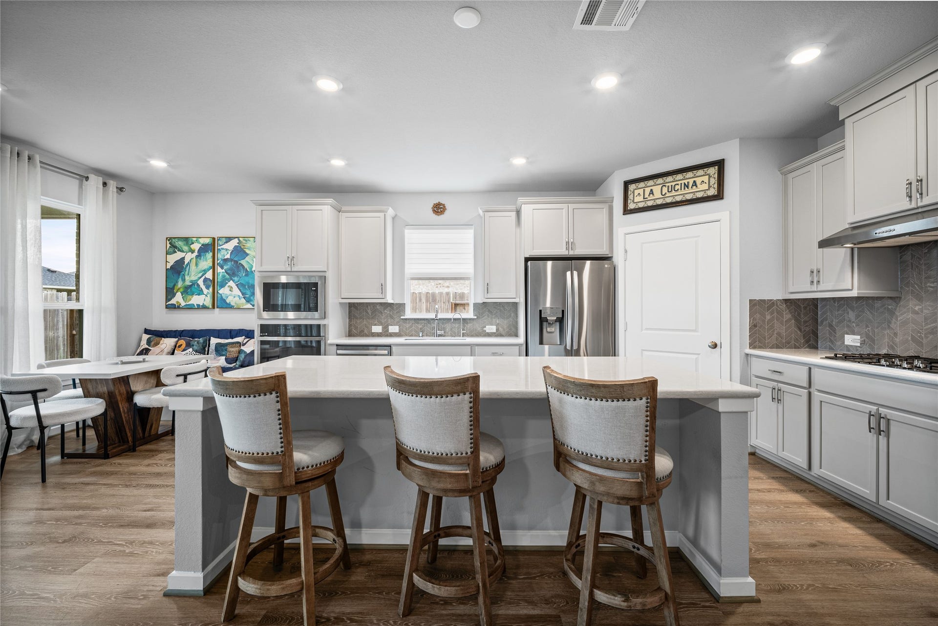 Another view highlights the generous island, abundant cabinetry and open layout at the heart of the home.