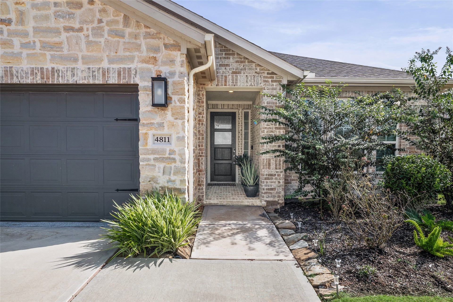 A welcoming first look at this beautifully maintained Taylor Morrison home with attractive brick and stone details.