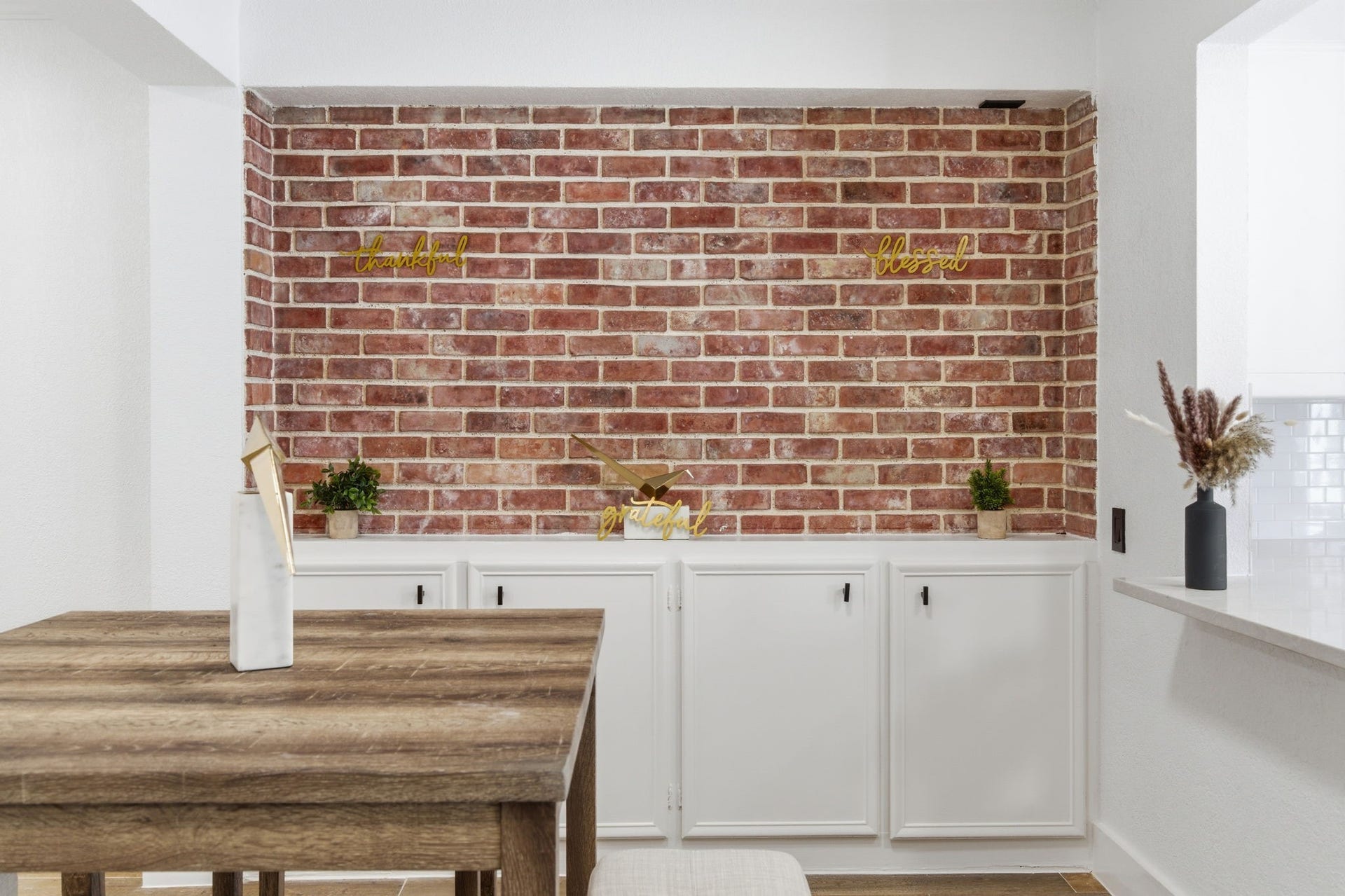 811 Lovett Boulevard, #21, Houston, TX 77006 Exposed brick brings warmth and texture to the dining area while the cabinetry below adds practical storage.