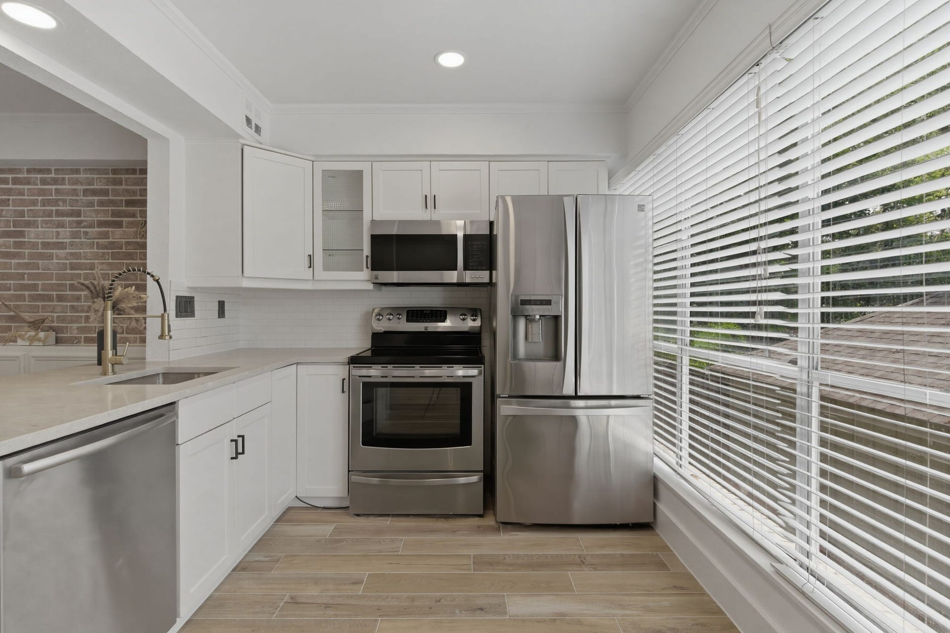 811 Lovett Boulevard, #21, Houston, TX 77006 A wall of windows brings natural light into the kitchen and makes the white cabinetry and stainless steel appliances feel even brighter.