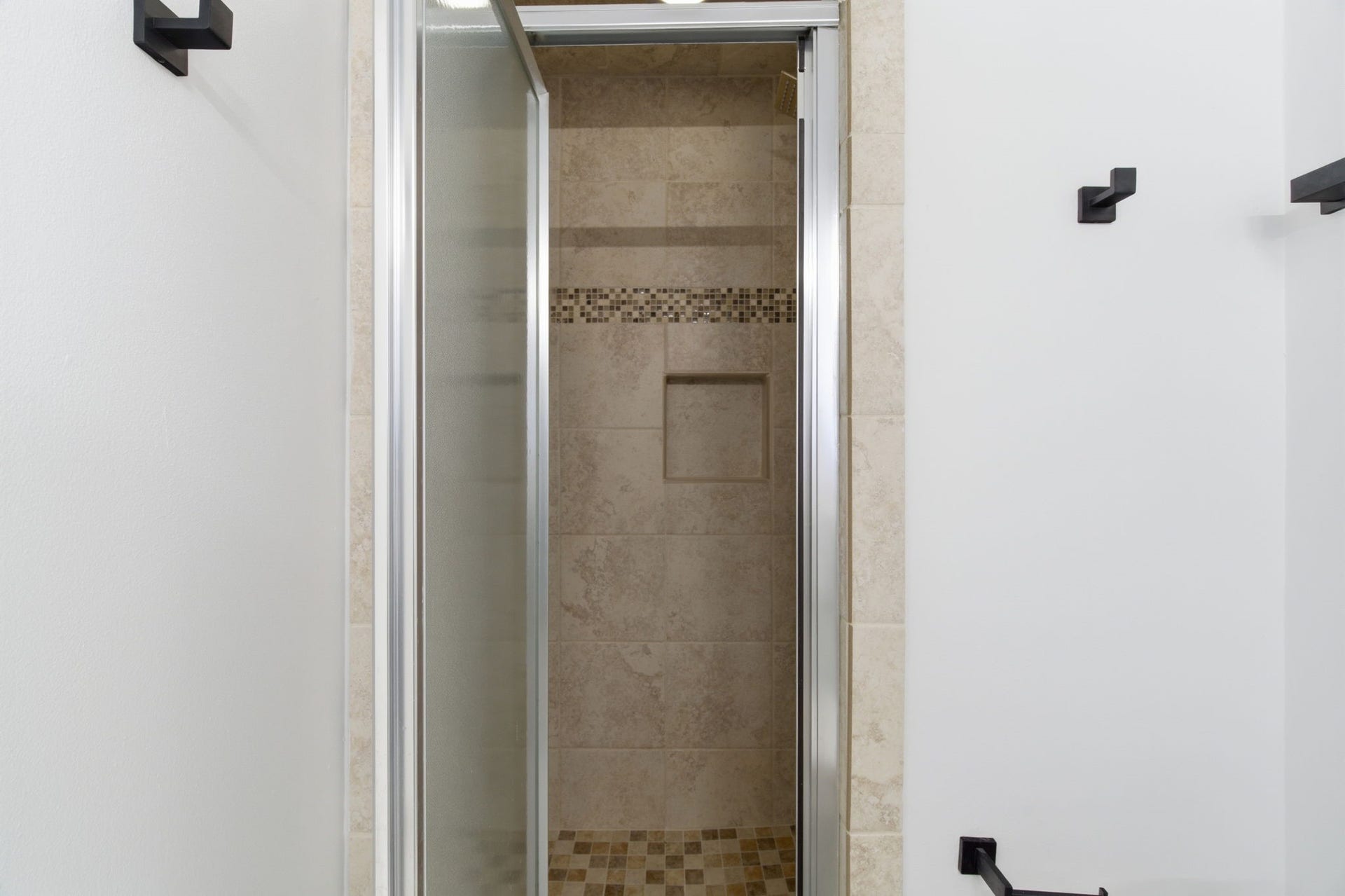 811 Lovett Boulevard, #21, Houston, TX 77006 The tiled walk in shower features a decorative mosaic accent and a built in storage niche.