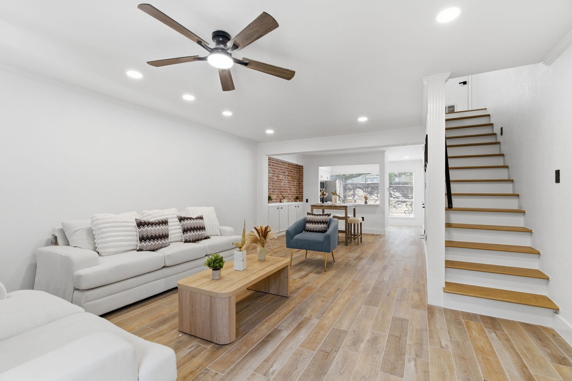 811 Lovett Boulevard, #21, Houston, TX 77006 The open living room sets the tone with warm wood look tile, recessed lighting, and a clear view through the dining area and kitchen.