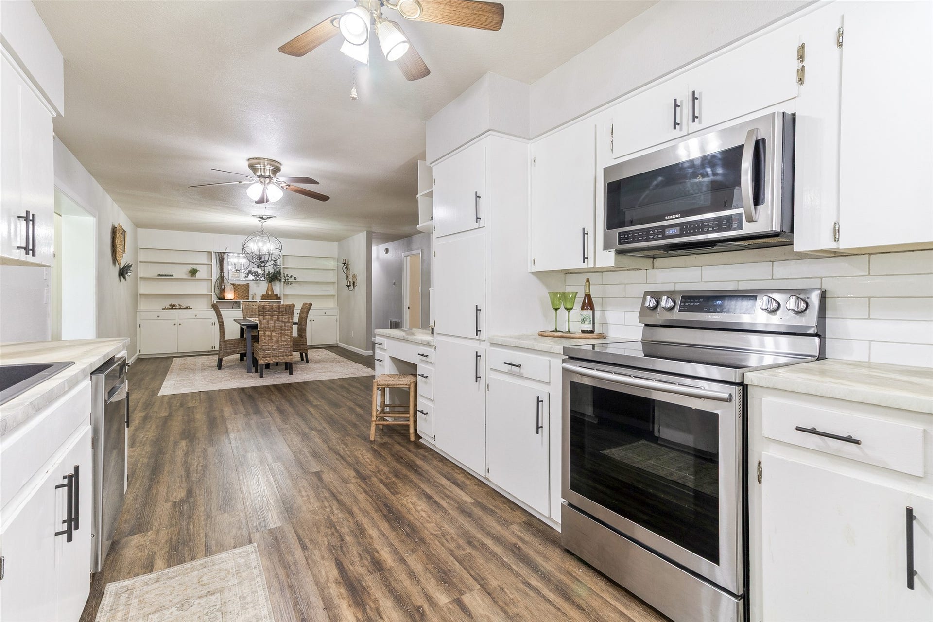 404 S 14th Street, West Columbia, TX 77486 Easy access to both dining areas simplifies serving, while a stainless steel microwave and electric oven/range (2020) pair with an updated subway tile backsplash.
