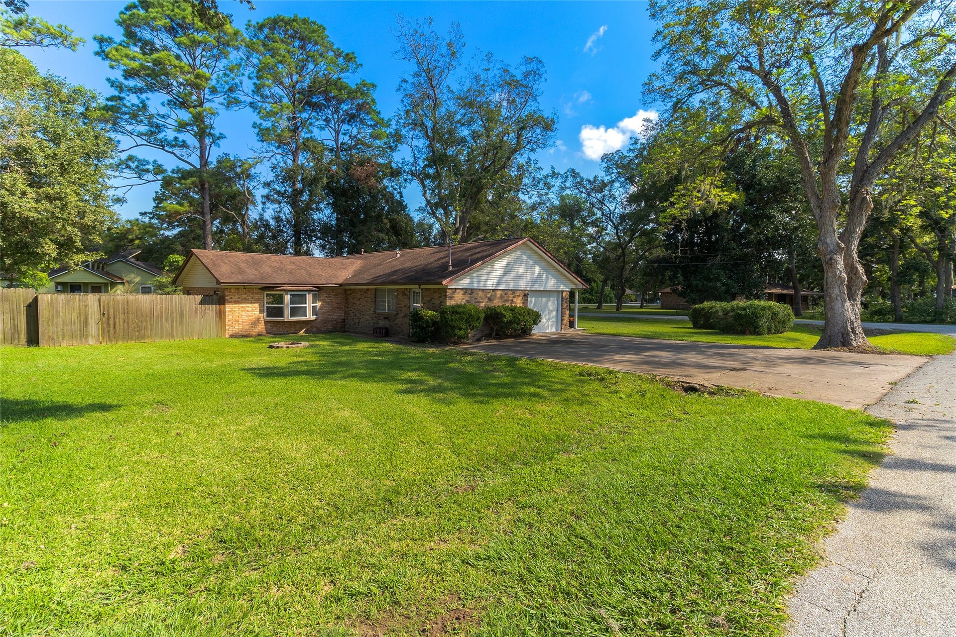 404 S 14th Street, West Columbia, TX 77486 A broad lawn and mature trees surround this one-story brick home, with a double-wide driveway leading to the attached 1-car garage. Roof (2018). Water Heater (2024). Bay Windows (2022).