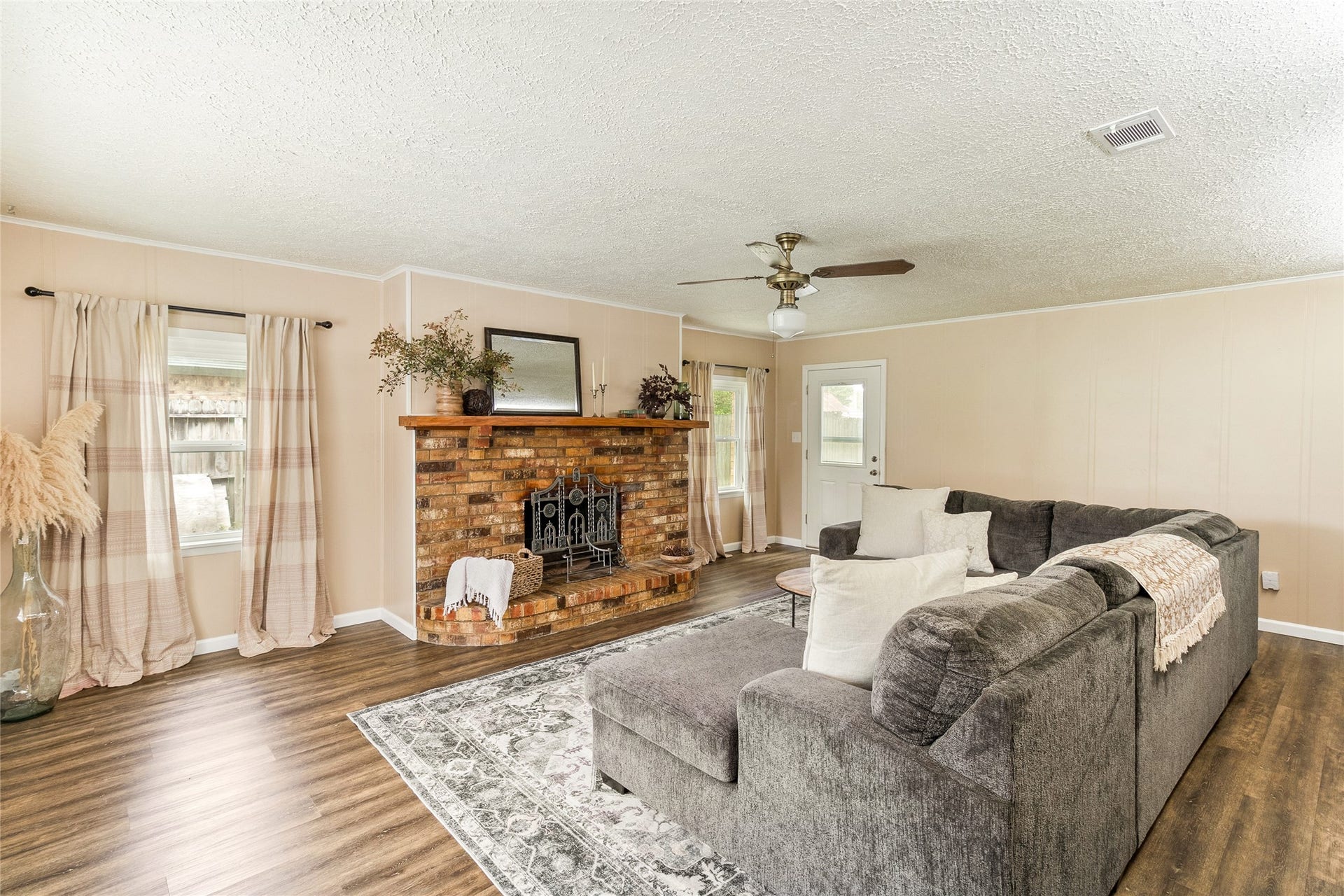 404 S 14th Street, West Columbia, TX 77486 A brick fireplace with gas connections anchors the spacious family room, where generous windows and backyard access create a comfortable destination beyond the front living space.