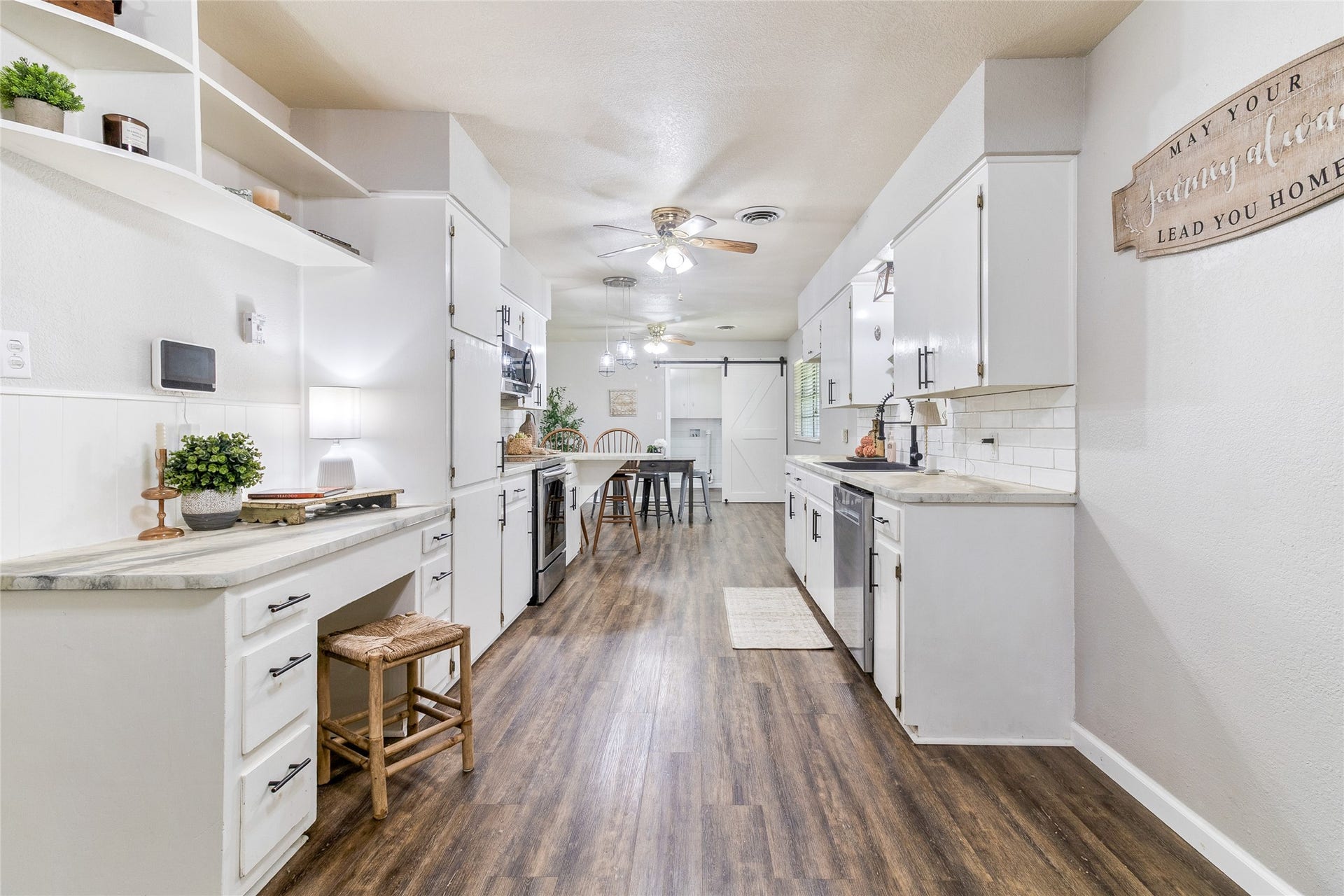 404 S 14th Street, West Columbia, TX 77486 White cabinetry, stainless steel appliances, ample counter space and breakfast bar seating create a kitchen ready for cooking and gathering.