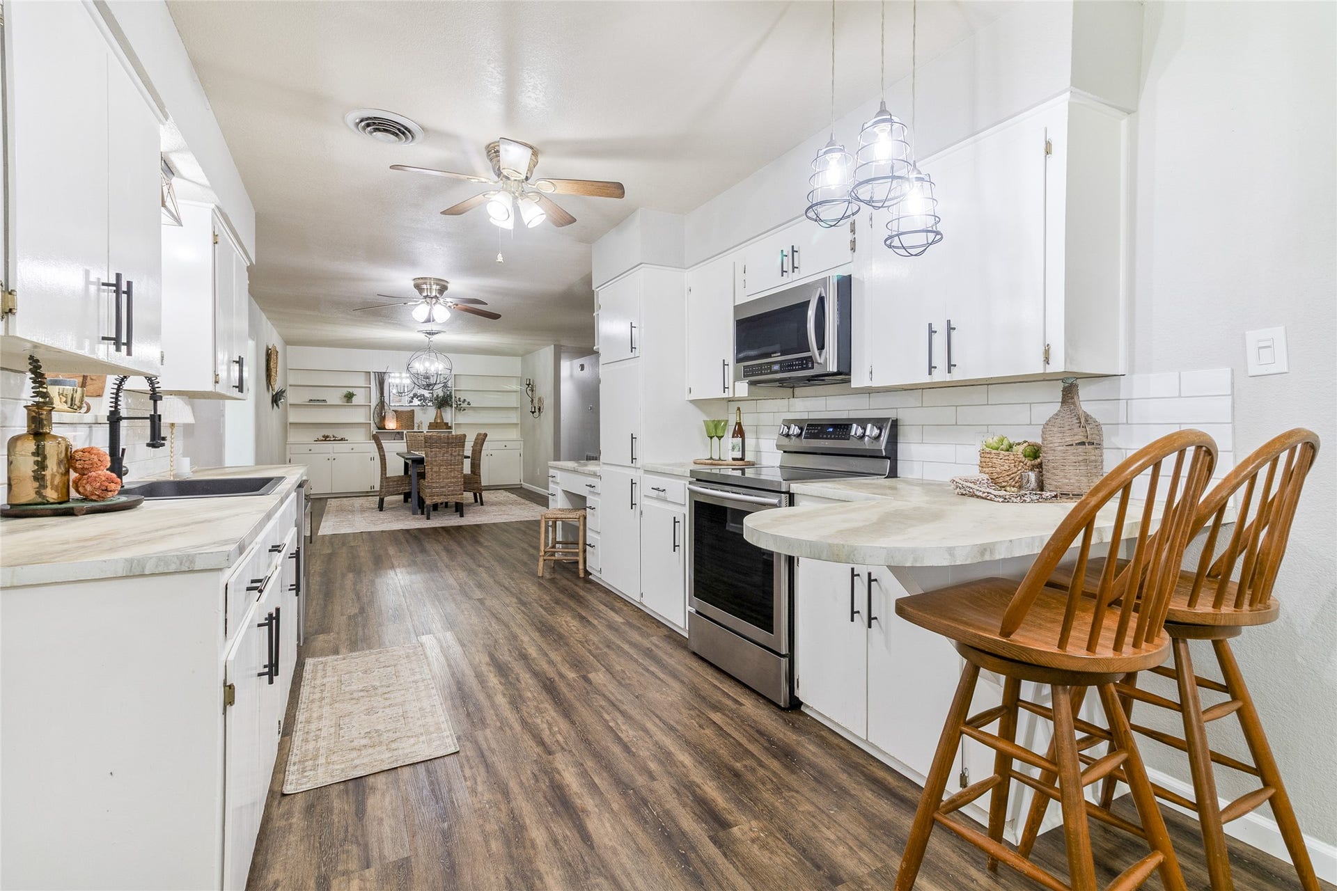 404 S 14th Street, West Columbia, TX 77486 Epoxy resin countertops (2020) extend to the breakfast bar seating for quick meals or conversation during prep, with chic pendant lighting overhead.