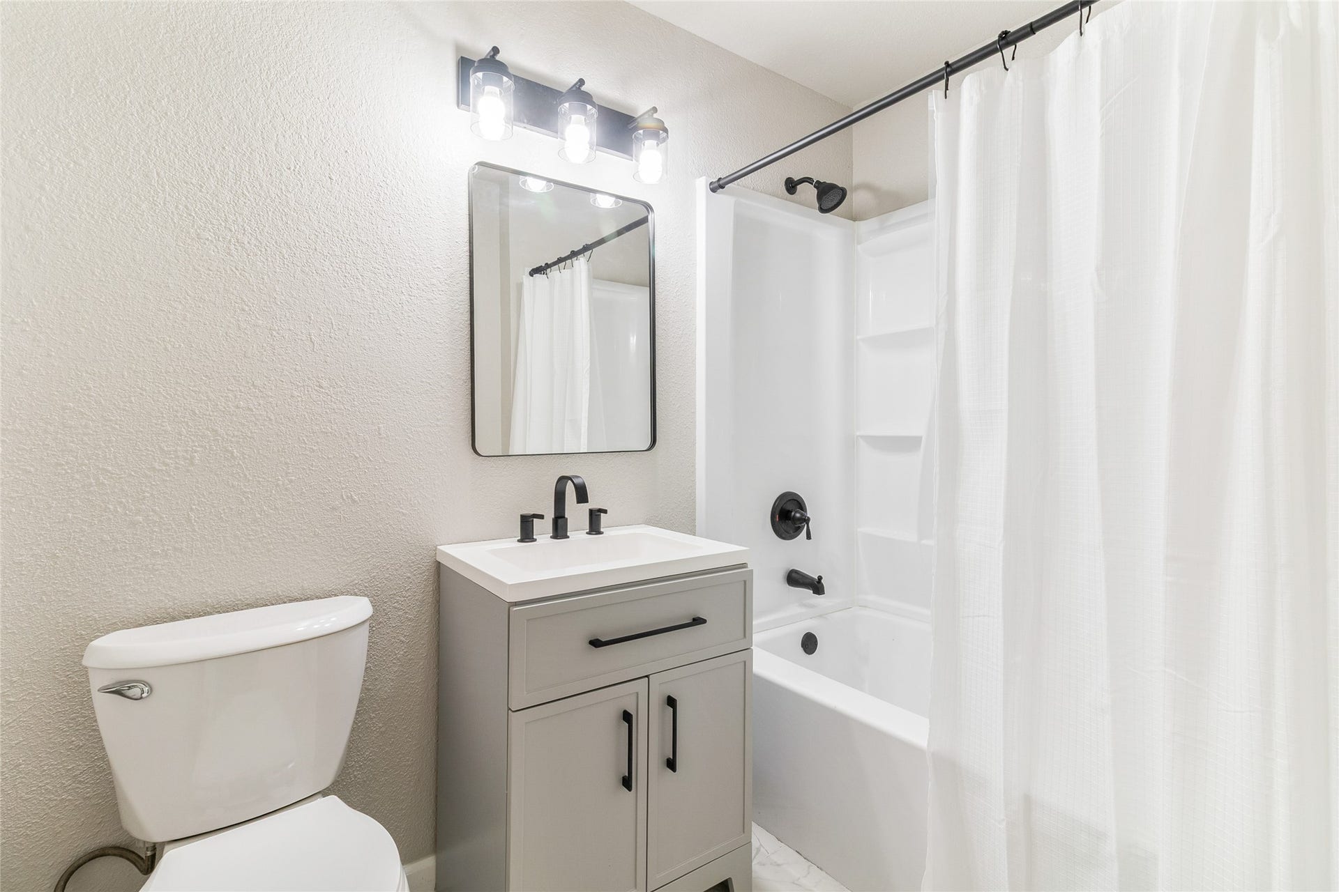 404 S 14th Street, West Columbia, TX 77486 Converted from a half bath in 2025, this full hallway bathroom serves the secondary bedrooms and guests with a tub/shower combination, updated vanity and lighting, and tile flooring.