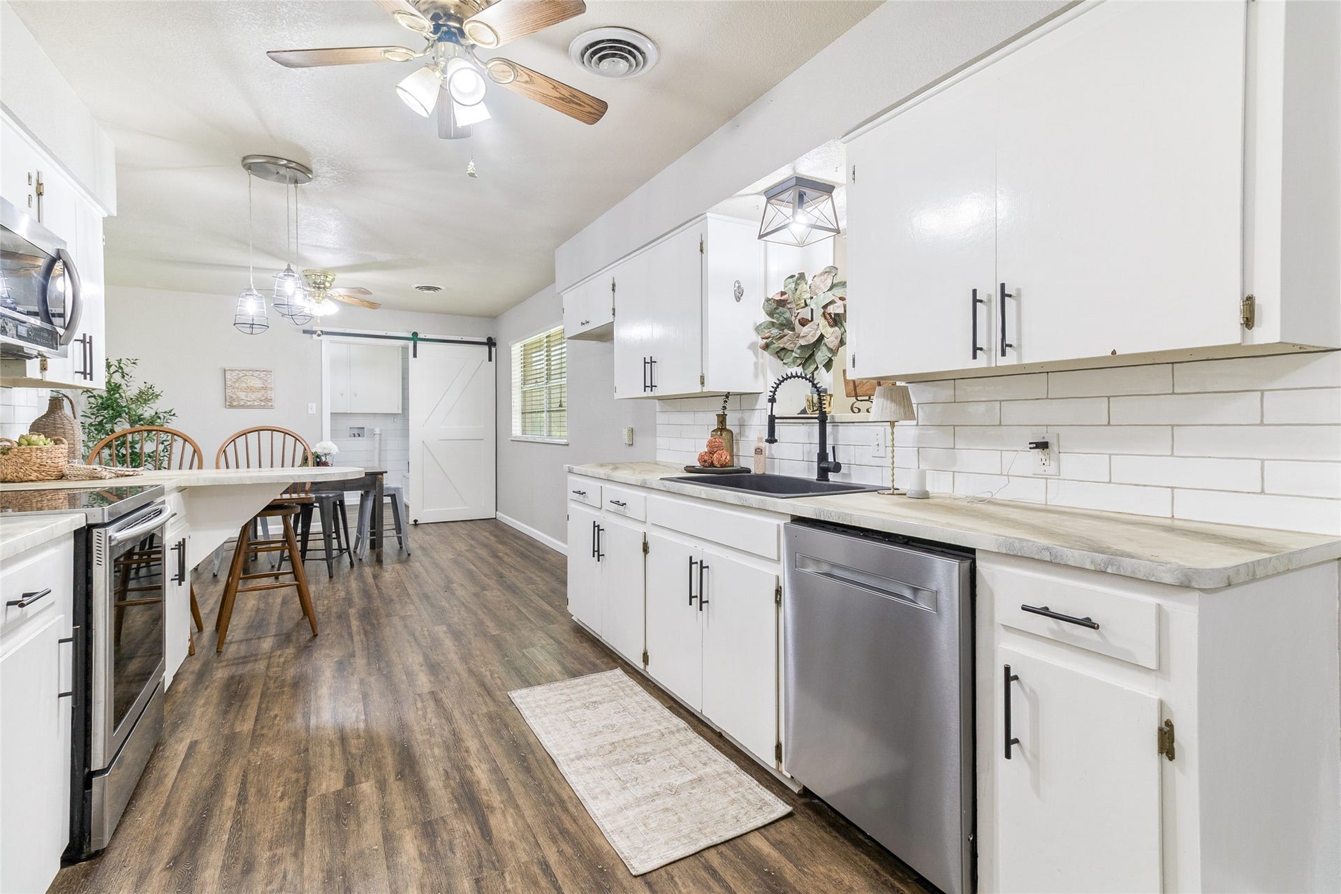 404 S 14th Street, West Columbia, TX 77486 Streamline cleanup with a sink and faucet (2020), a Midea three-rack dishwasher (2025) and updated lighting above the sink overlooking the Family Room.