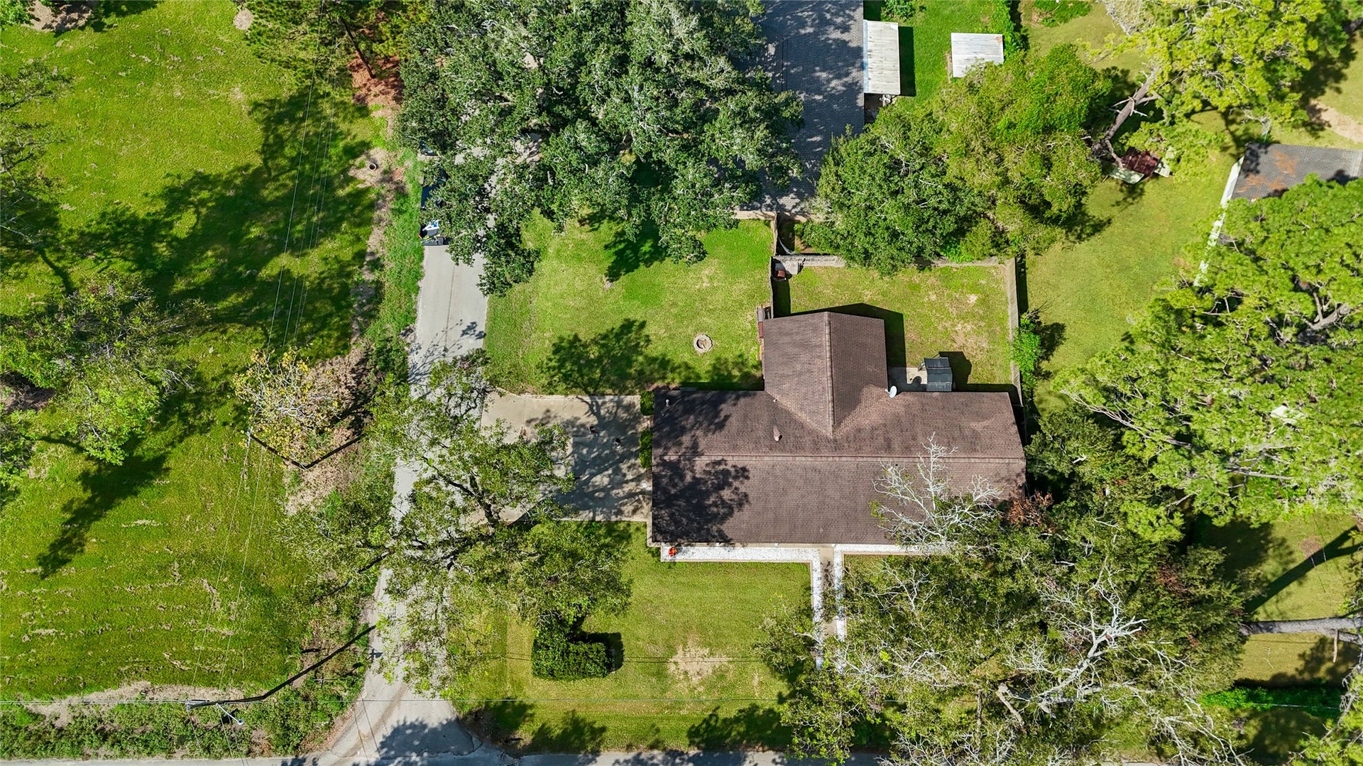 404 S 14th Street, West Columbia, TX 77486 Aerial view highlights the 0.22-acre corner lot, mature tree canopy and the arrangement of the home, driveway and fenced backyard.