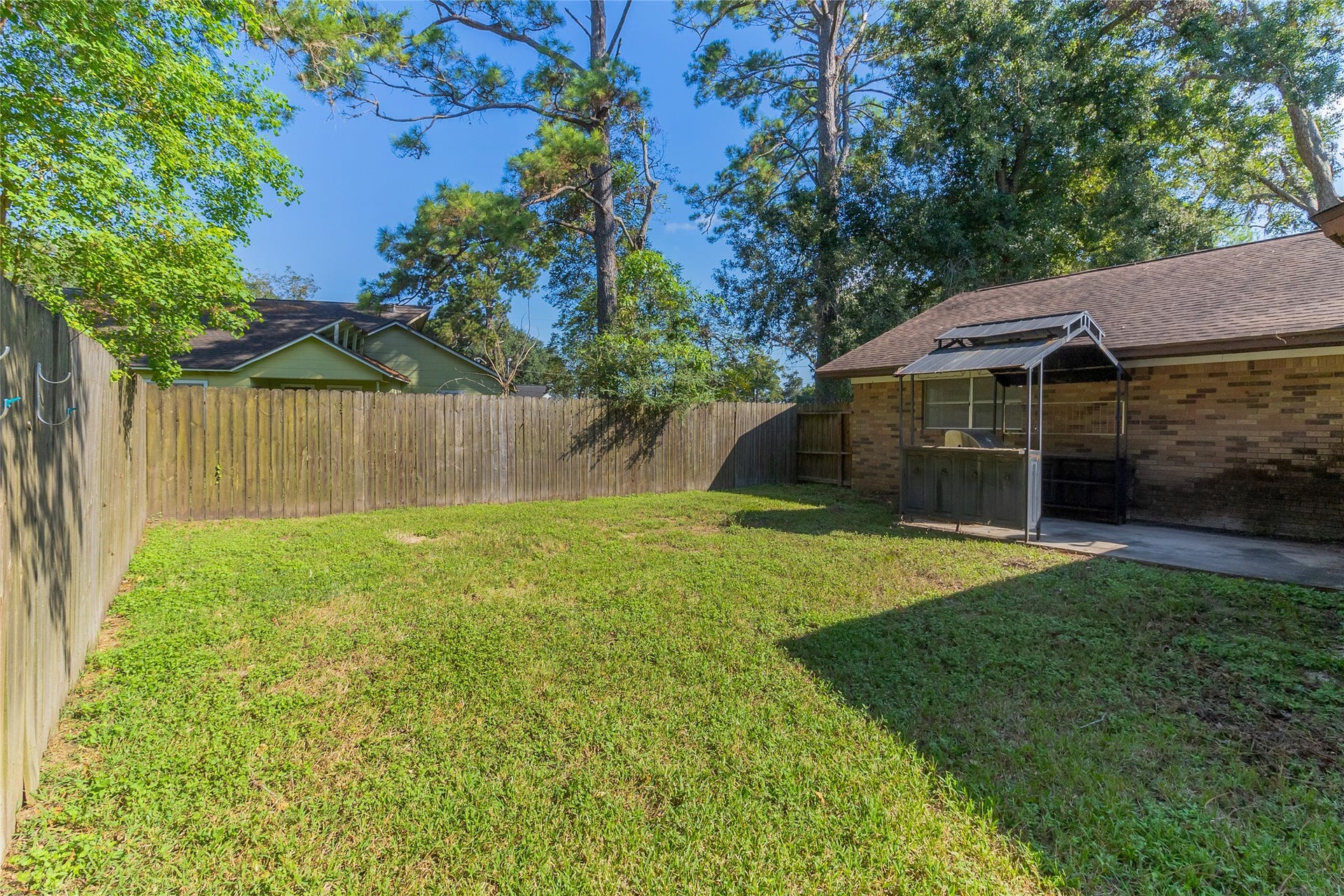 404 S 14th Street, West Columbia, TX 77486 Backyard access from the family room connects indoor gathering space to a concrete patio area with room for outdoor activities.
