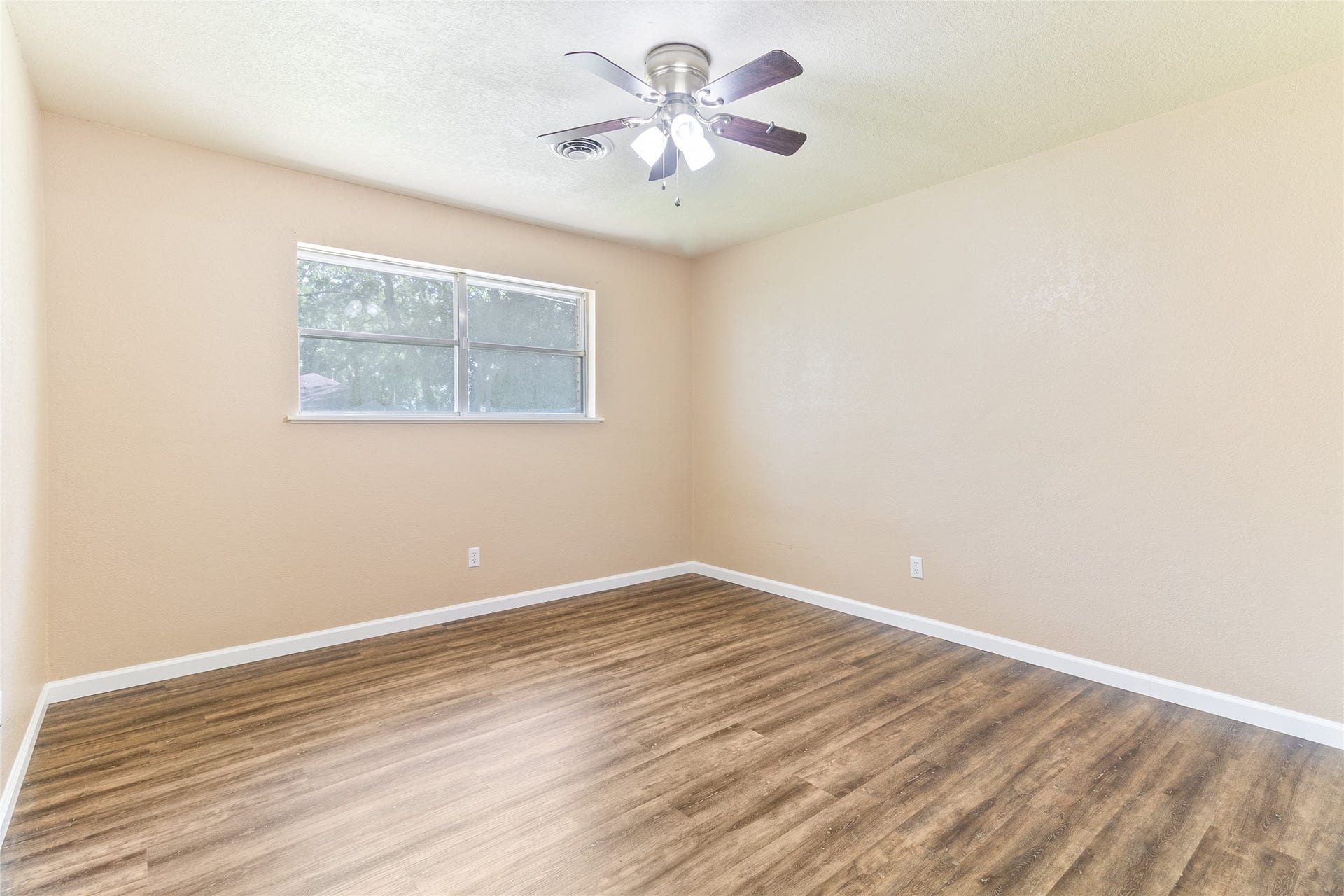 404 S 14th Street, West Columbia, TX 77486 Bedroom #3 (12x12) pairs front-yard views with a high-set side window, leaving wall space for a bed, dresser or desk.