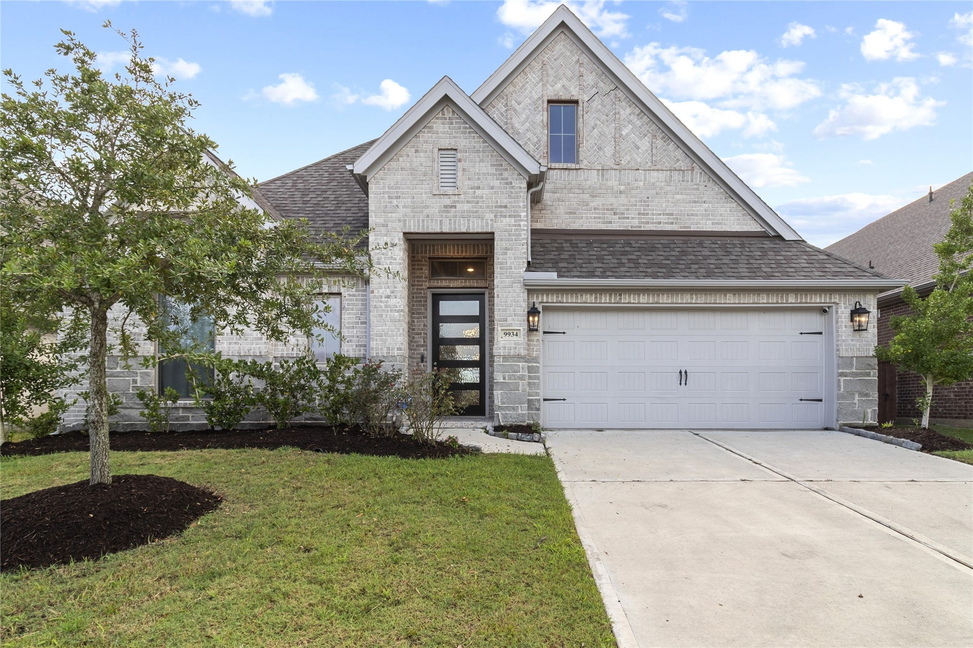 9934 Starry Night Lane, Manvel, TX 77578 Charming single-story home with a modern brick exterior, featuring a welcoming front porch and a spacious two-car garage.