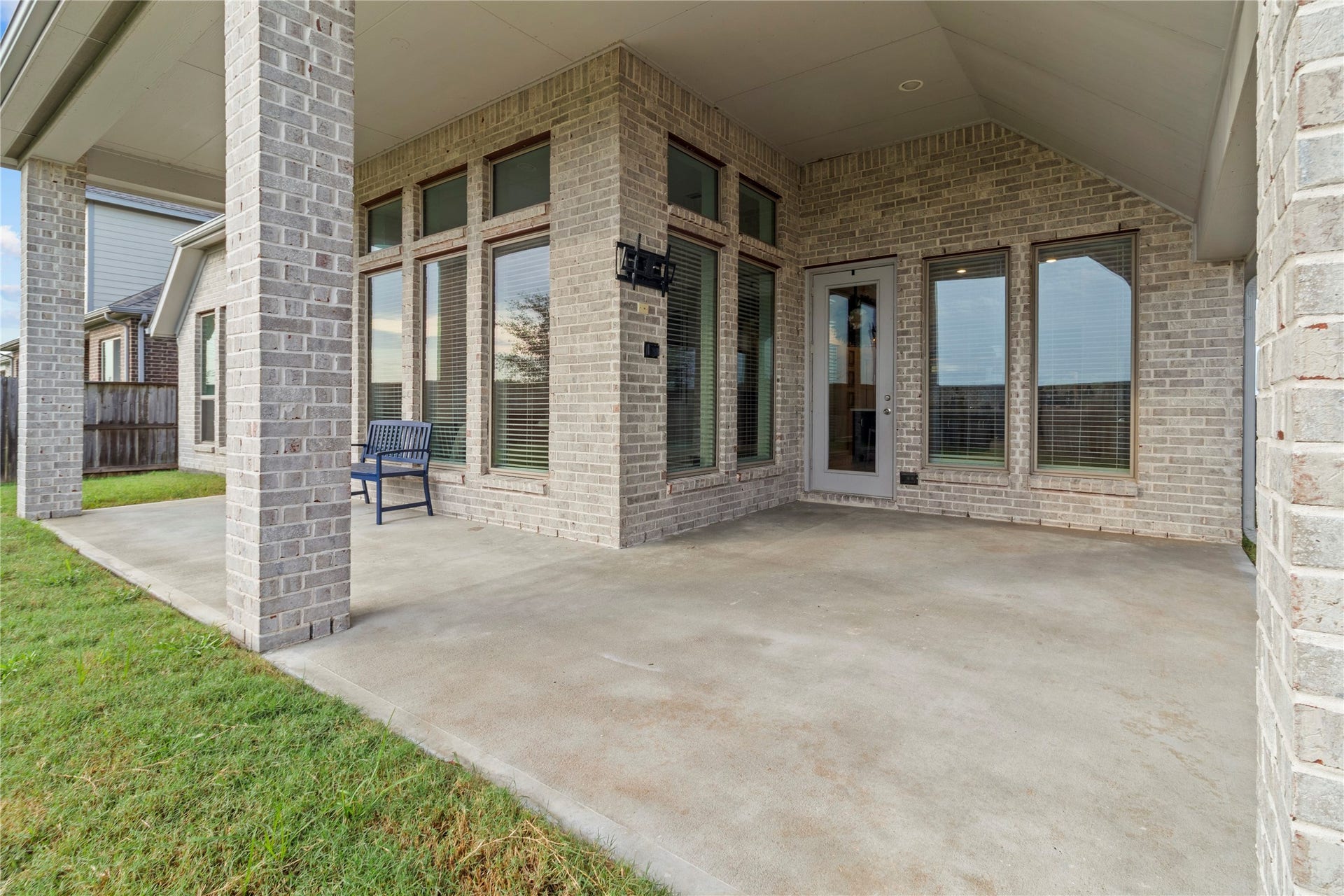 9934 Starry Night Lane, Manvel, TX 77578 Spacious covered patio with elegant brickwork and large windows, perfect for outdoor entertaining and relaxation.