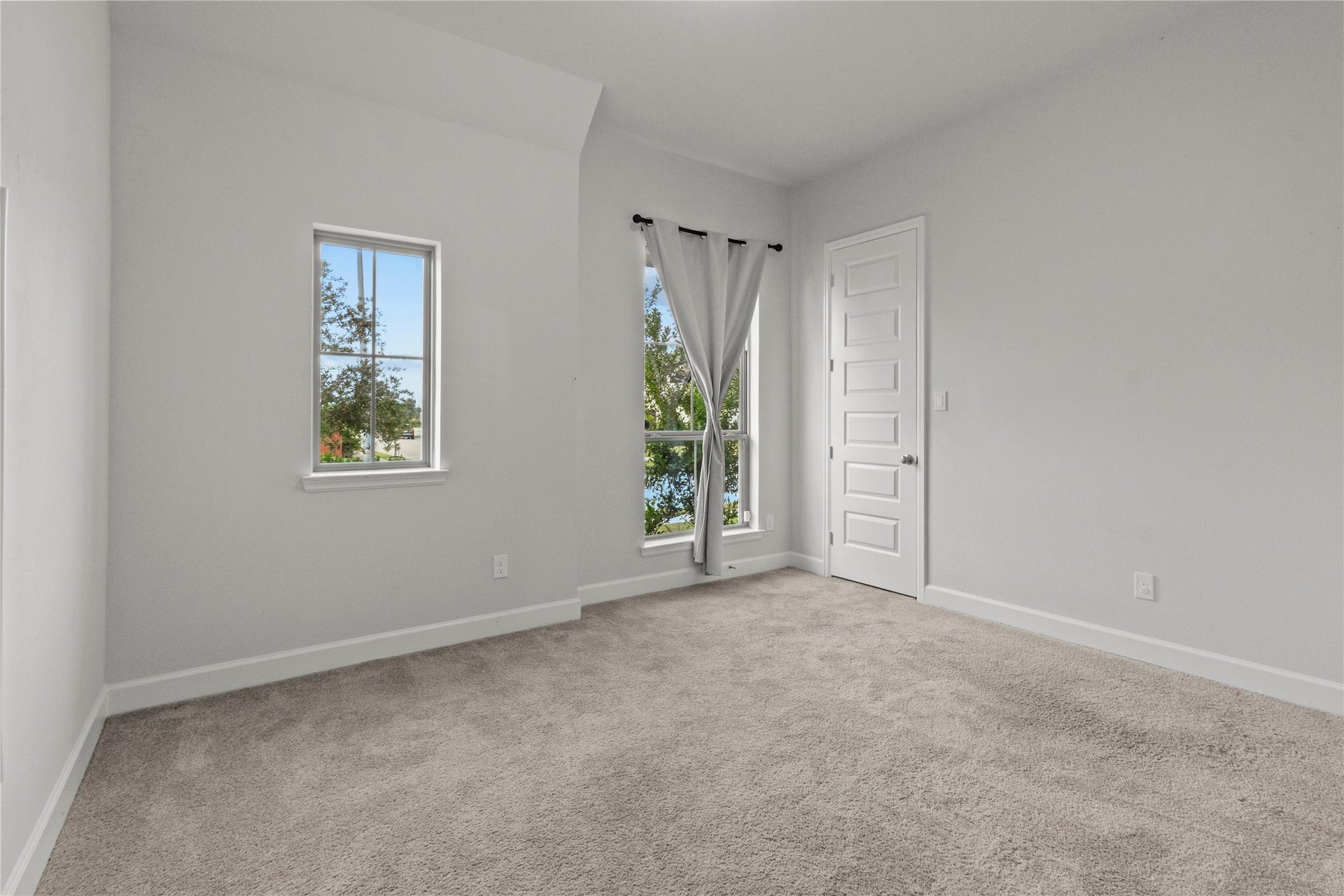 9934 Starry Night Lane, Manvel, TX 77578 Bright and airy room with plush carpeting, large windows for natural light, and a modern white door. Bedroom1