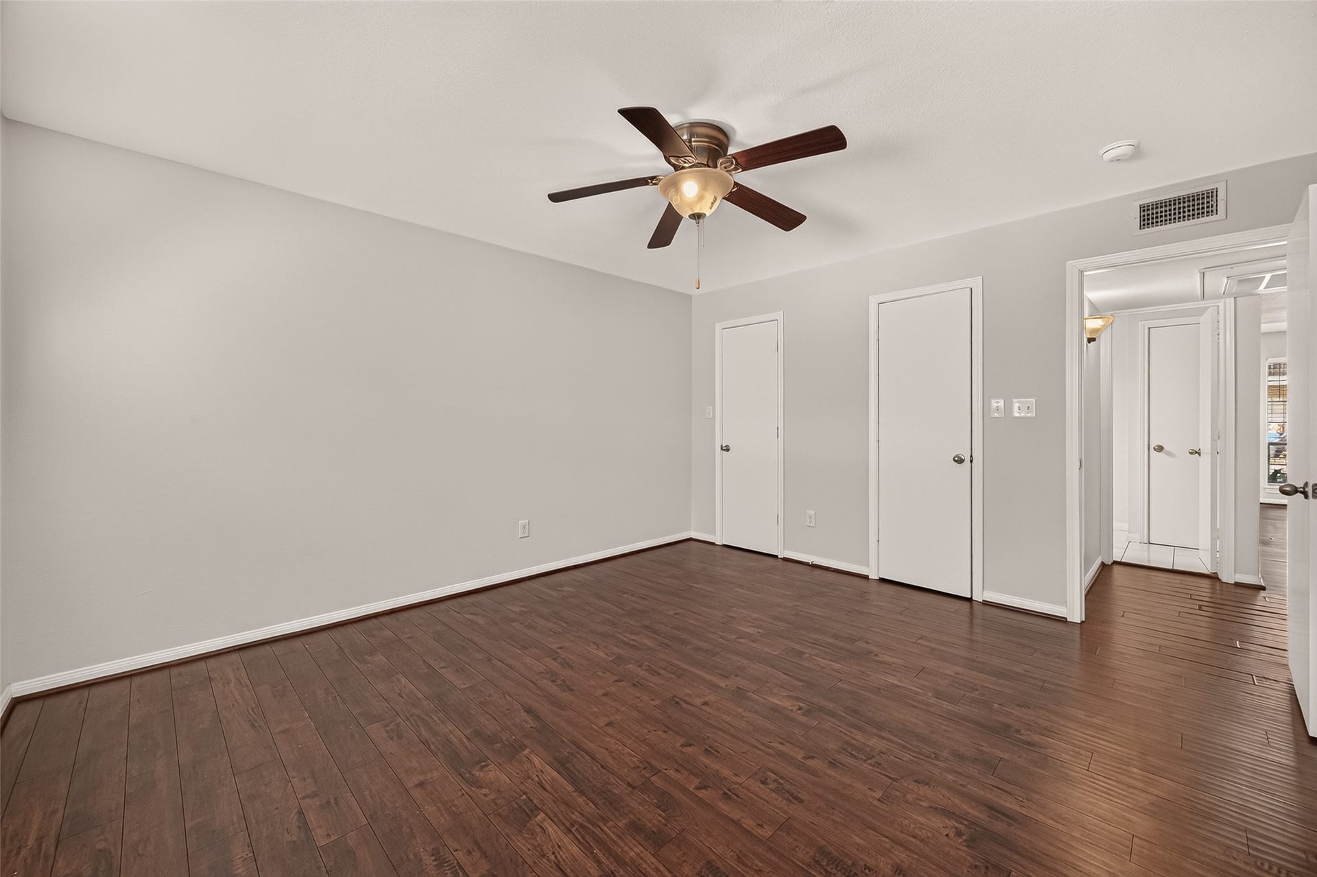 5343 Richmond Avenue, #4, Houston, TX 77056 Spacious bedroom featuring rich wood flooring, a modern ceiling fan, and ample closet space, offering comfort and style.