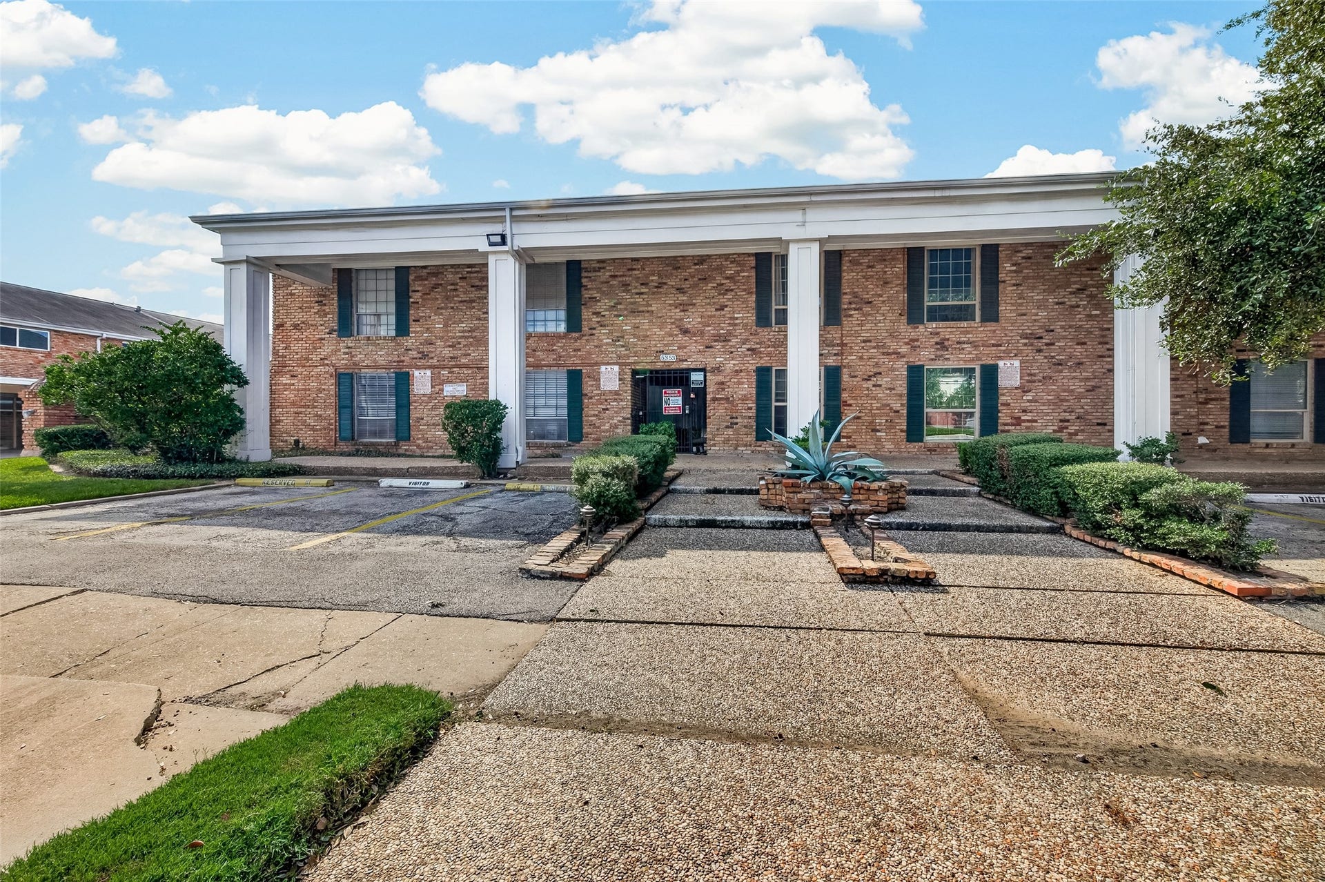 5343 Richmond Avenue, #4, Houston, TX 77056 Charming brick building with classic columns and well-maintained landscaping, offering ample parking space and a welcoming entrance.