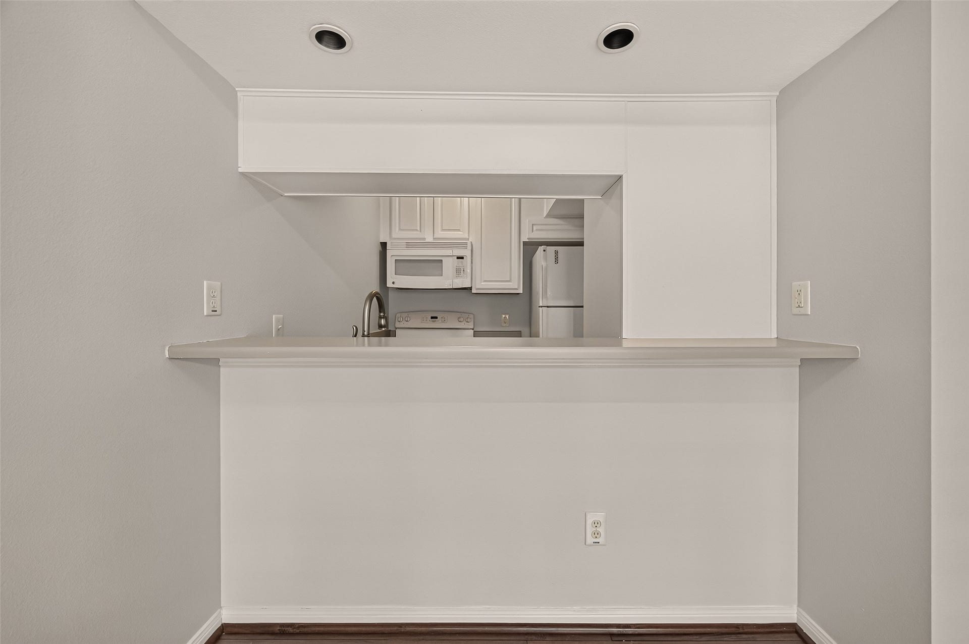 5343 Richmond Avenue, #4, Houston, TX 77056 Cozy kitchen with a pass-through bar, featuring sleek white cabinetry, modern appliances, and recessed lighting for a bright, inviting space.