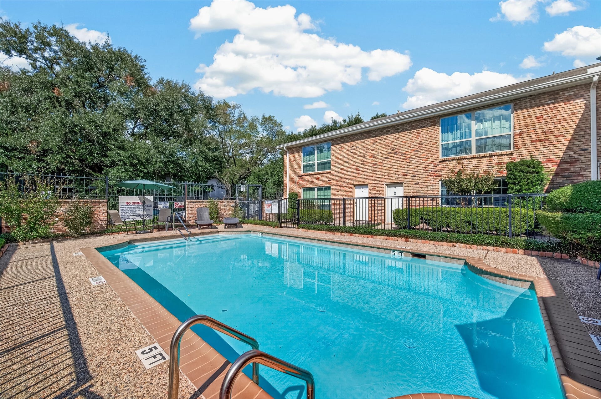 5343 Richmond Avenue, #4, Houston, TX 77056 Enjoy a refreshing swim in this inviting community pool, nestled beside a charming brick building and surrounded by lush greenery.
