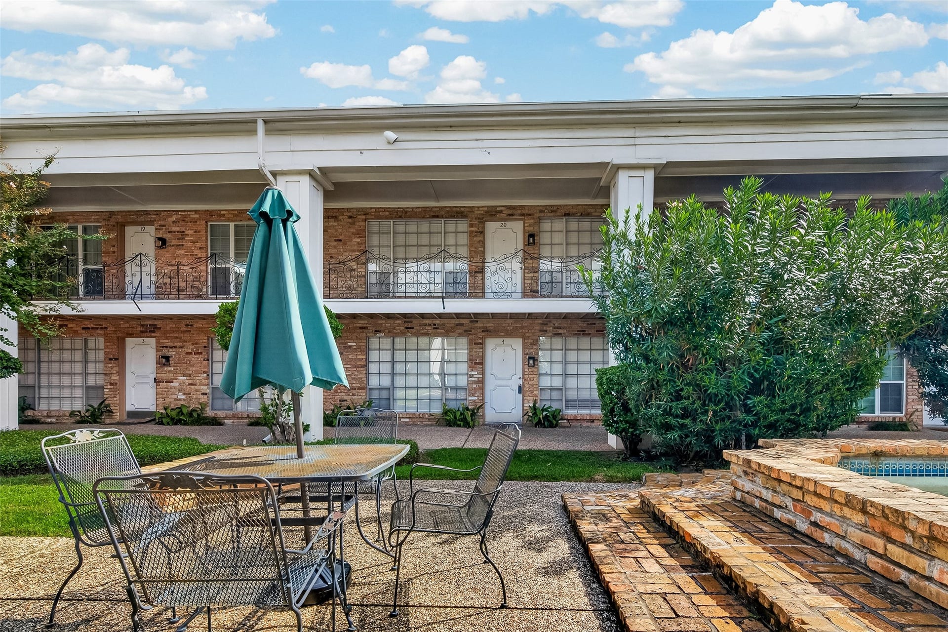 5343 Richmond Avenue, #4, Houston, TX 77056 Charming two-story brick home with classic ironwork details and inviting outdoor seating area, perfect for relaxation or entertaining.