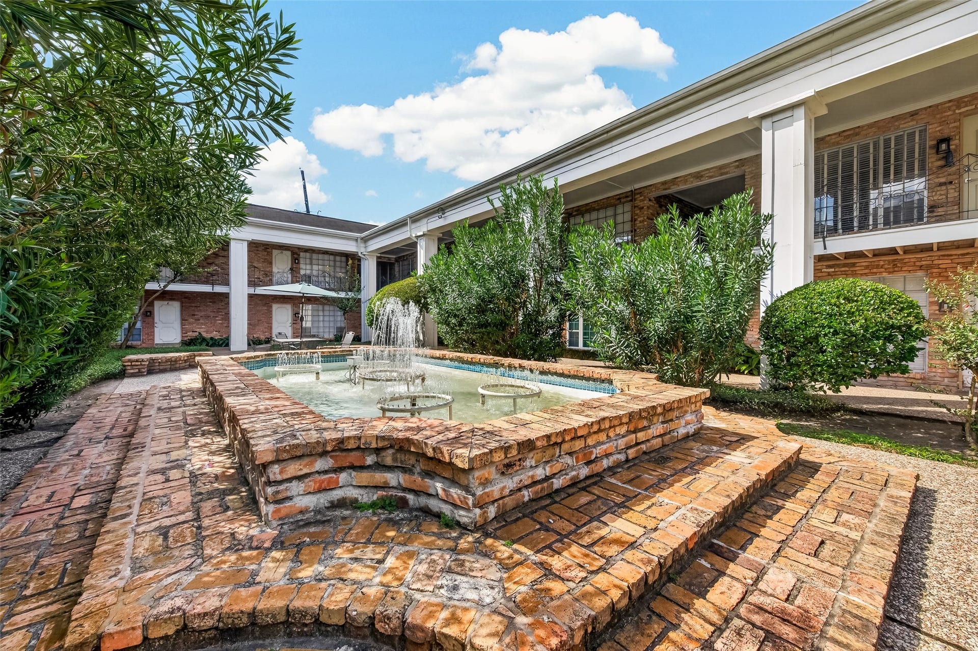 5343 Richmond Avenue, #4, Houston, TX 77056 Charming brick courtyard featuring a central fountain and lush greenery, perfect for relaxing outdoors.